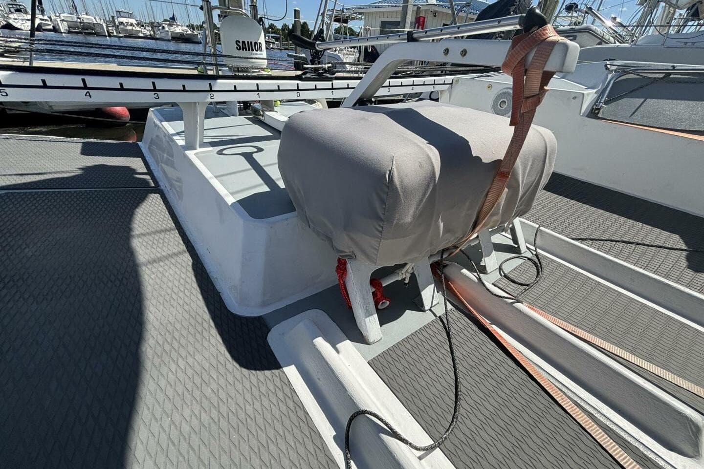 2009 Class 40 Akilaria RC2 yacht deck with covered equipment and marina background.