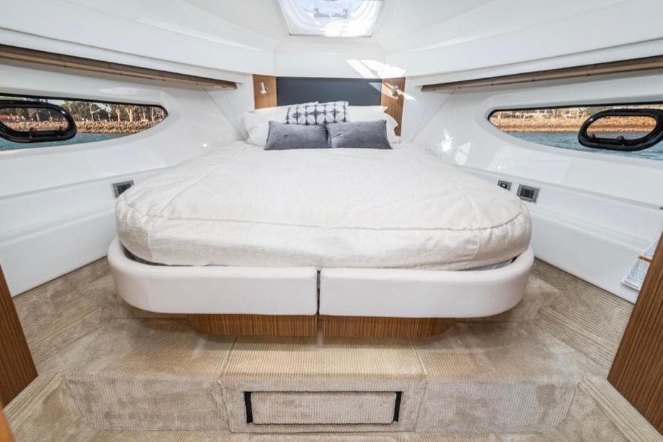 Luxurious cabin interior of 2017 Sea Ray 460 Sundancer yacht with cozy bed.