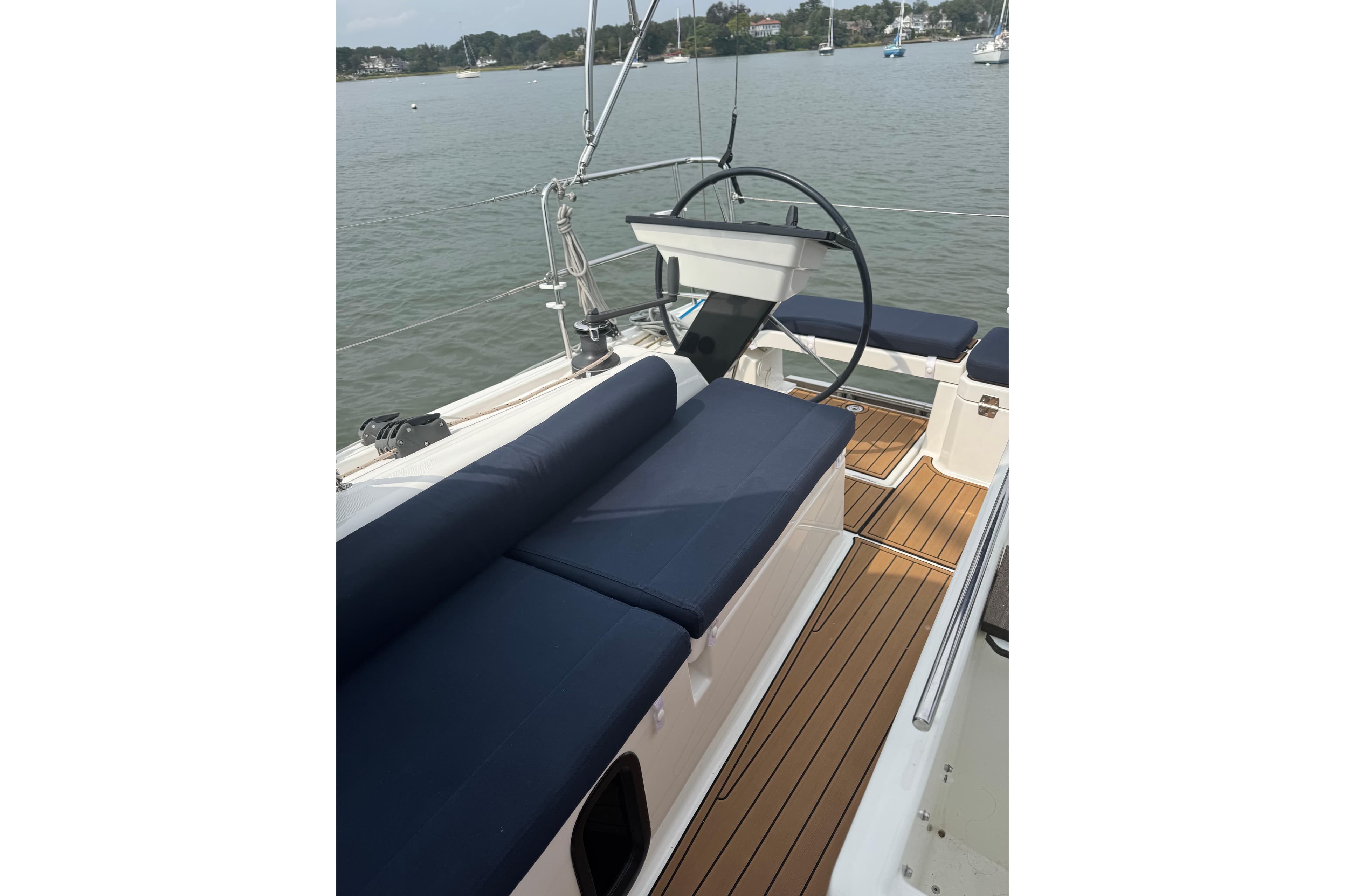 2023 Dufour 37 sailboat cockpit with blue cushions and wooden deck.