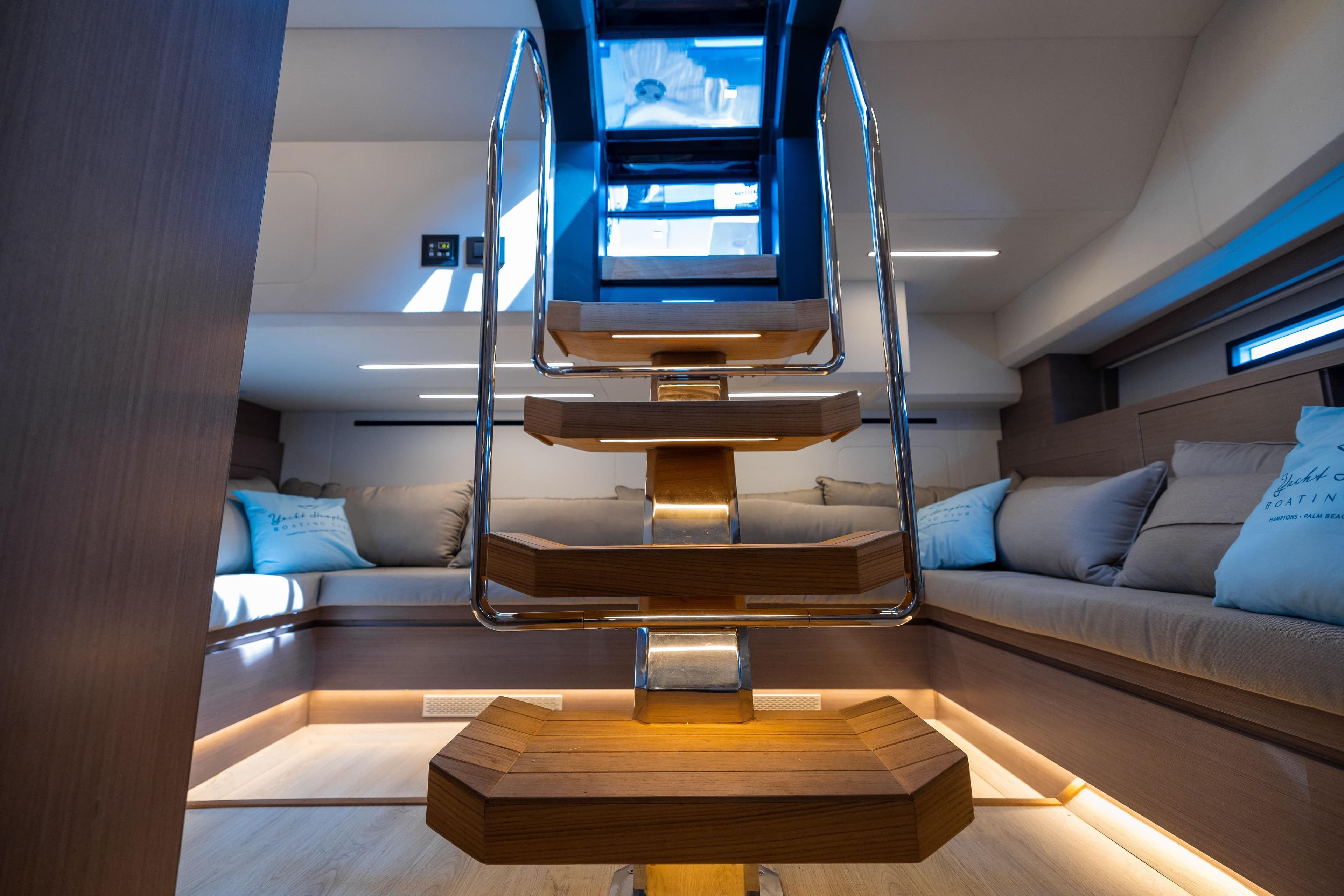 Luxurious interior of 2023 OKEAN 57 yacht with modern staircase and cozy seating area.