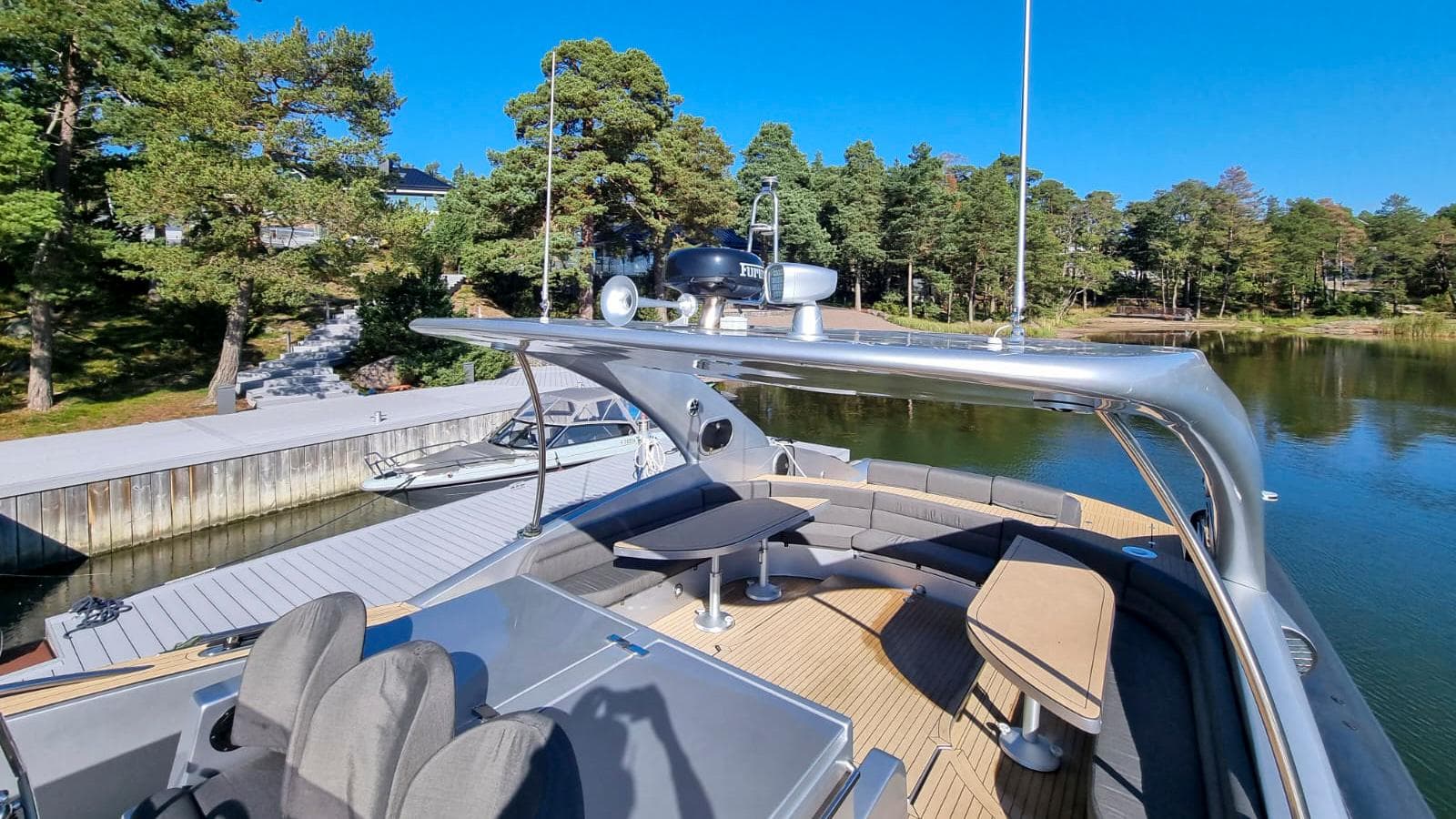 Luxurious 2008 Custom Cantieri Opera 60 yacht docked by a scenic, tree-lined waterfront.