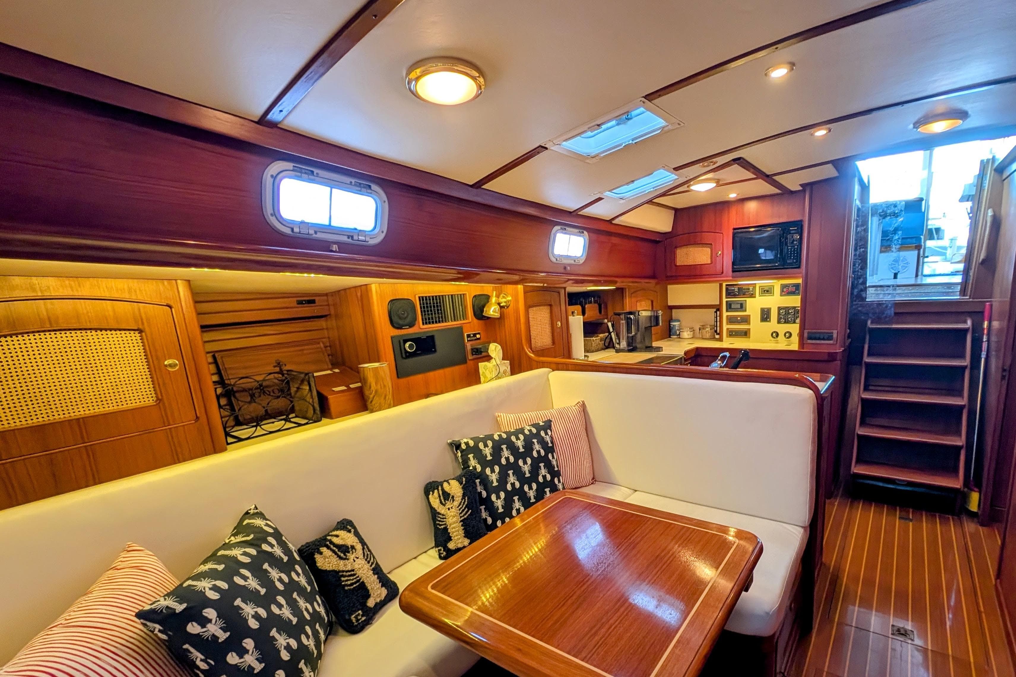 Interior of 1998 Little Harbor WhisperJet 55 yacht with cozy seating and wooden finishes.