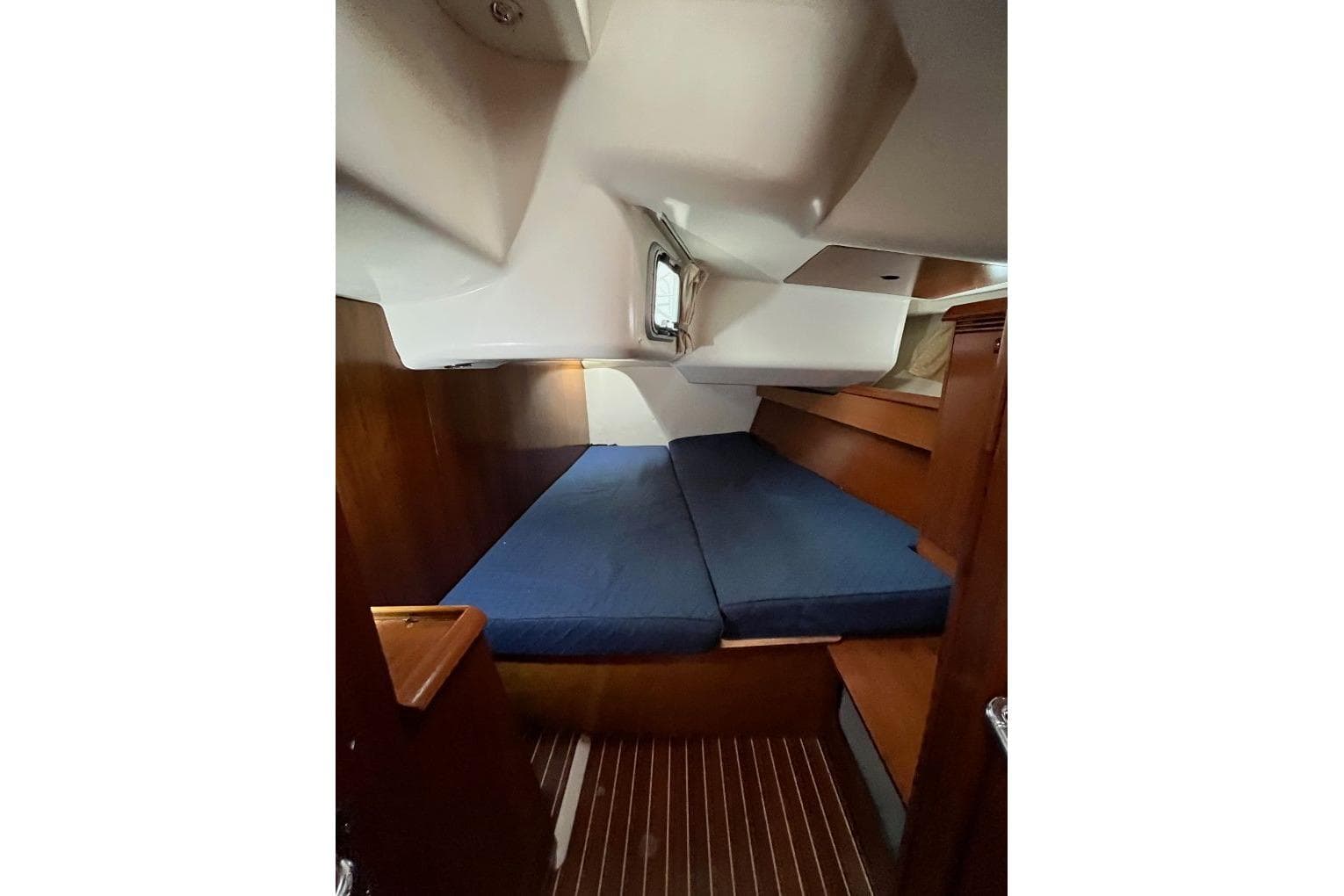 Interior cabin of 2008 Jeanneau Sun Odyssey 45 sailboat with blue cushions.