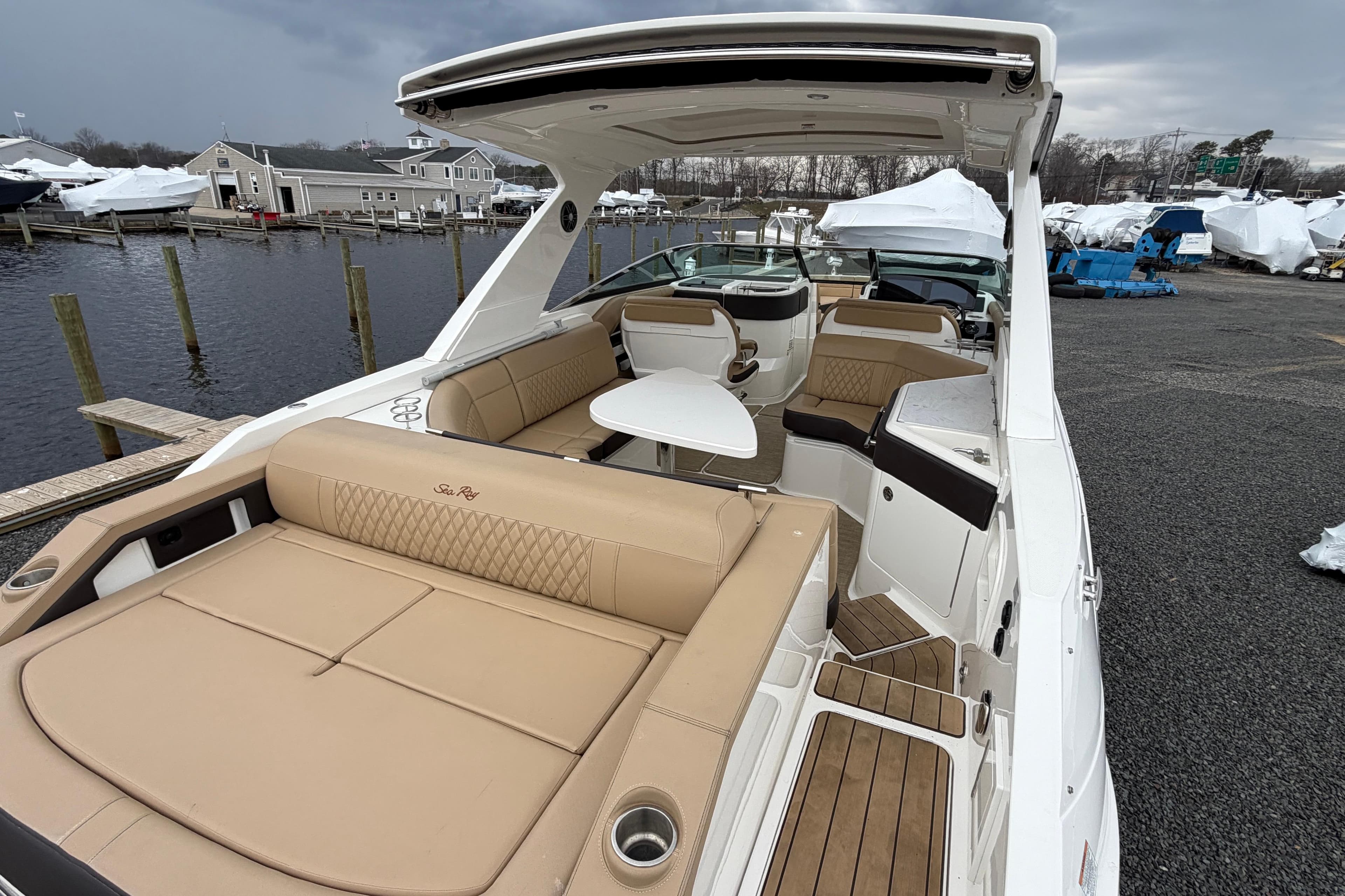 2023 Sea Ray SLX 310 Outboard boat with luxurious seating and sleek design at a marina.