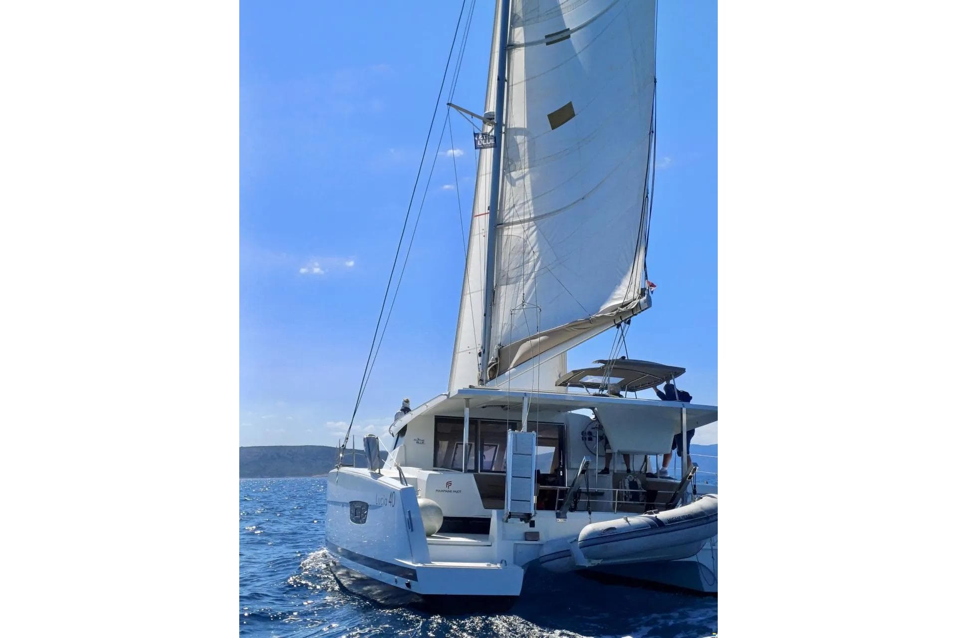 2017 Fountaine Pajot Lucia 40 sailing on open sea under clear blue sky.