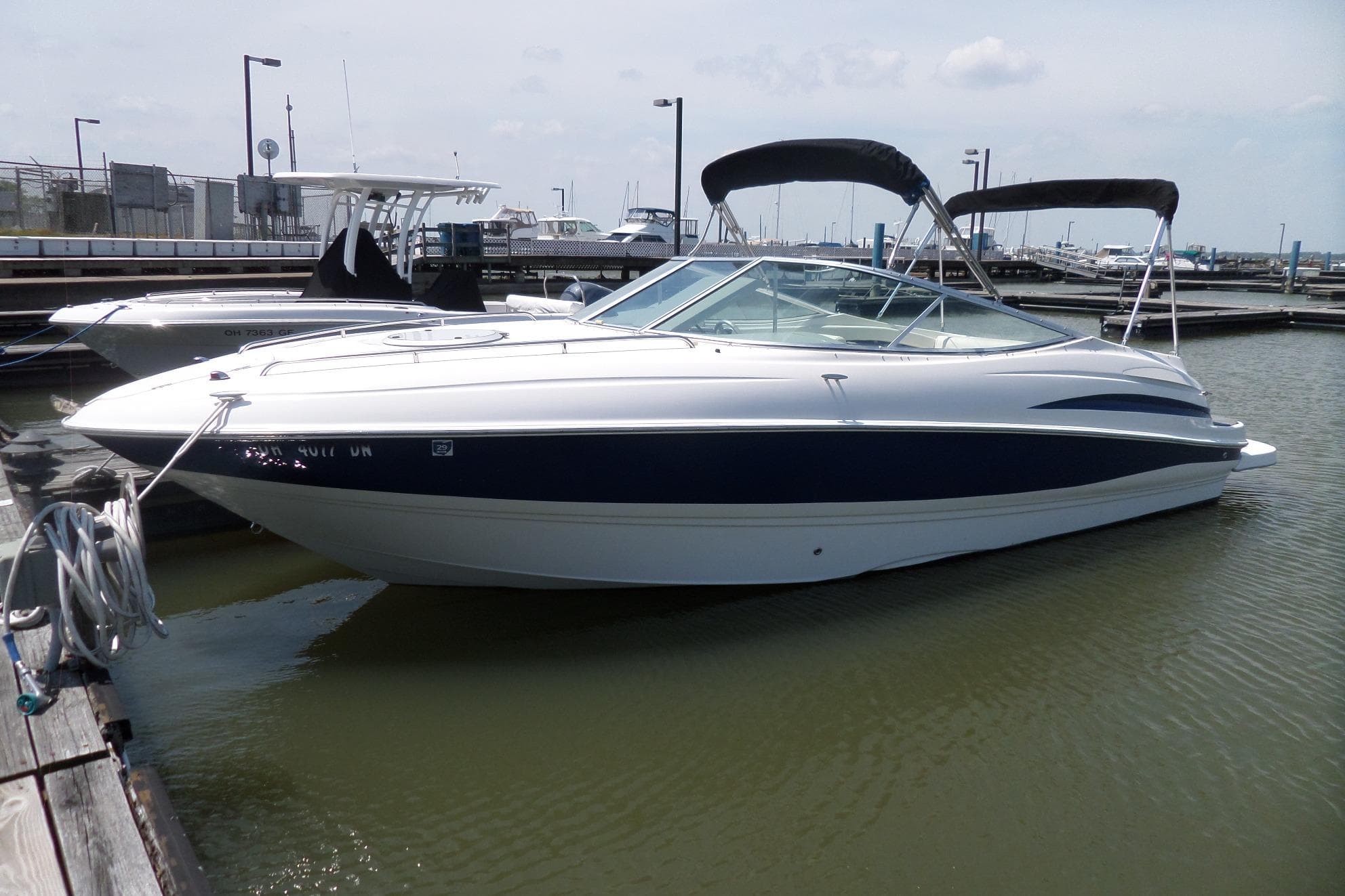 2003 Maxum 2400 SC boat docked in marina, featuring sleek design and canopy.