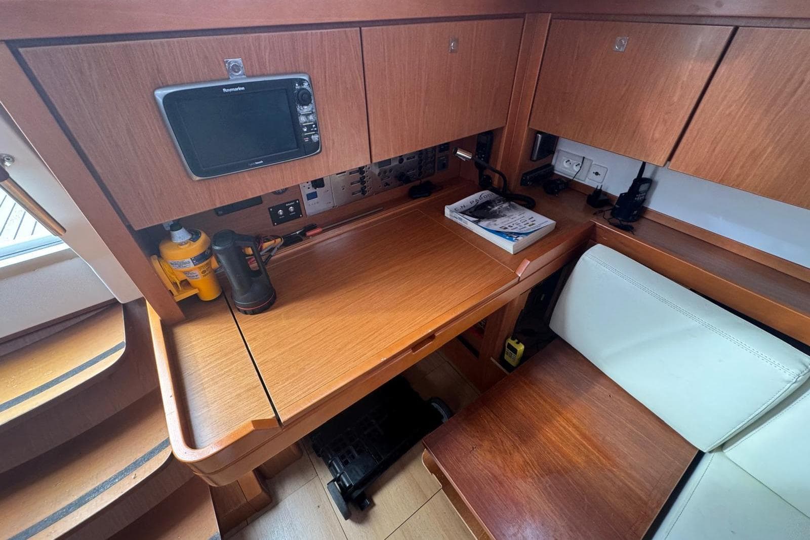 Navigation station in 2015 Beneteau Sense 50 yacht with wooden finish and equipment.