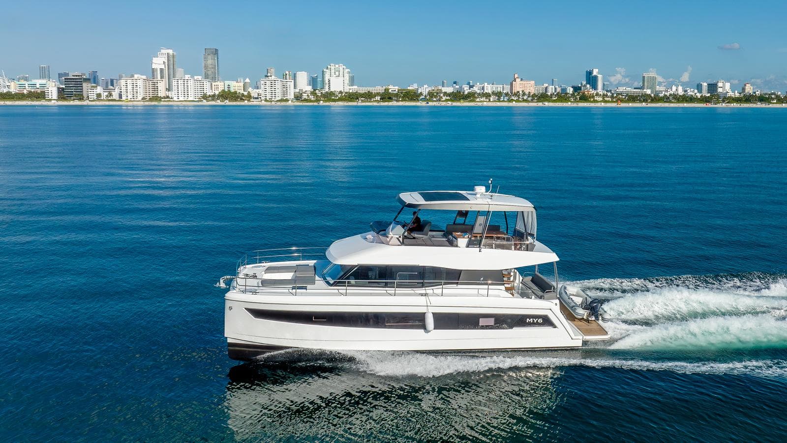 Fountaine Pajot MY 6 Yacht 2023 cruising on water near city skyline.