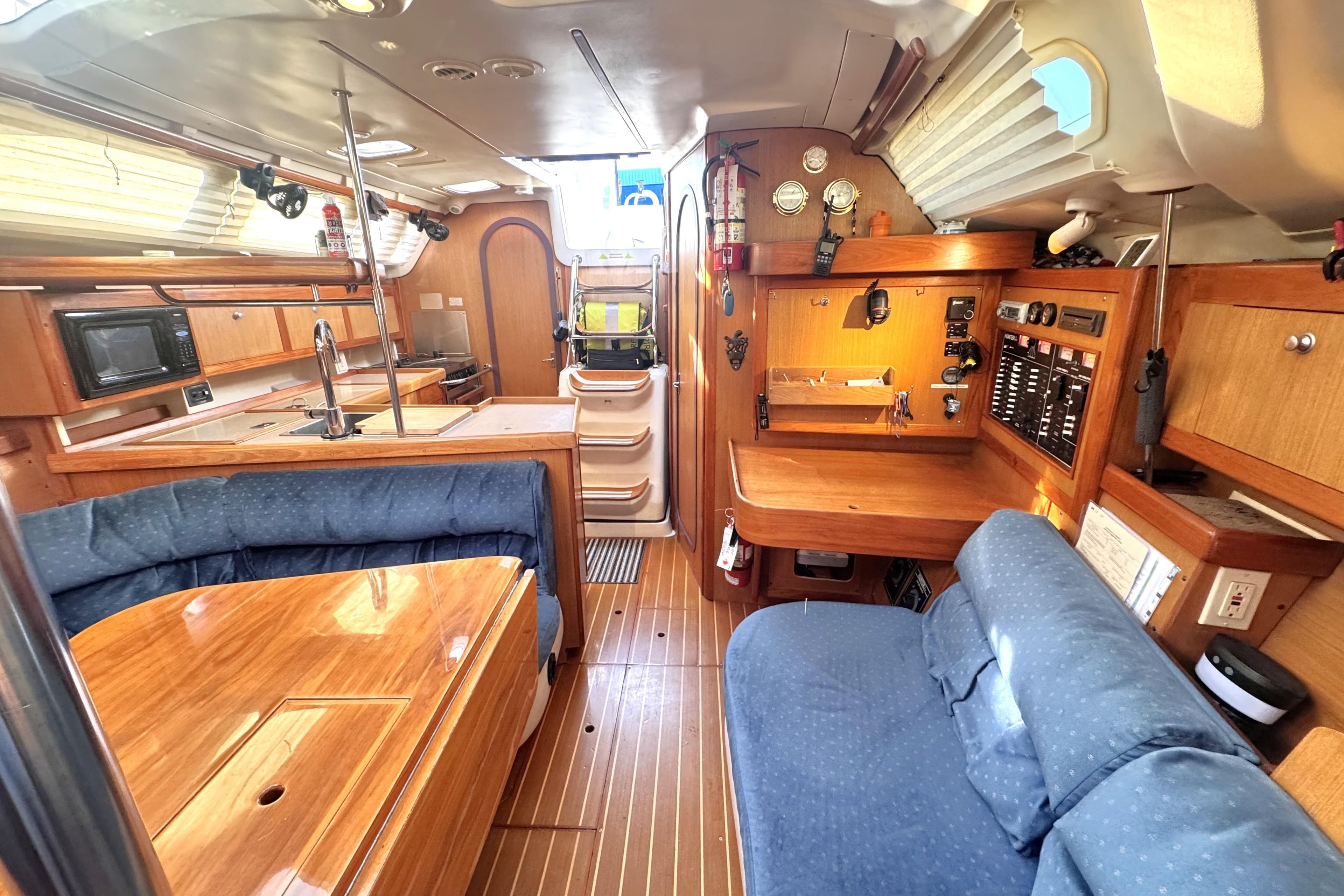 Interior of a 2000 Hunter 380 sailboat with wood finishes and blue upholstery.