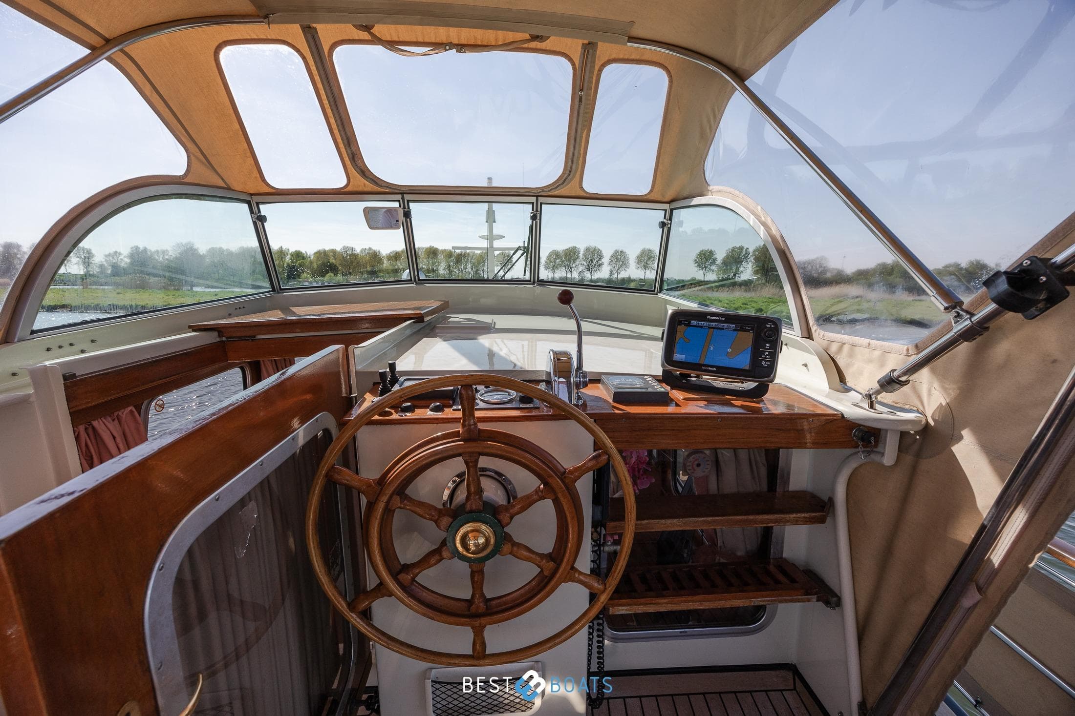 Interior view of 1986 Linssen St. Jozef 1050 Salon AK-L boat cockpit with wooden steering wheel.