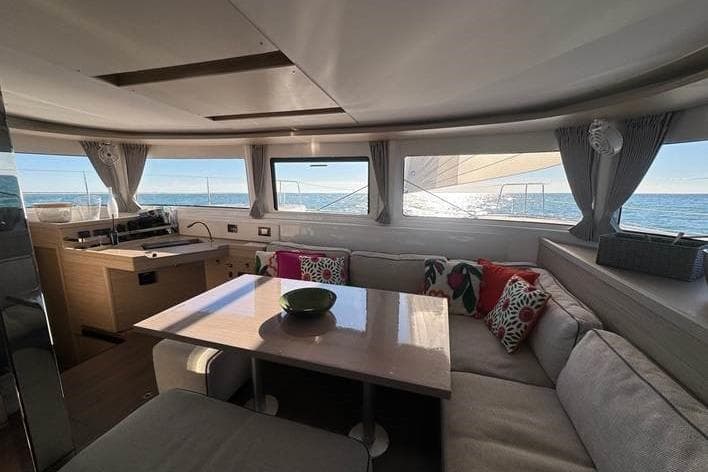Interior of 2023 Lagoon 46 catamaran with modern seating and ocean view.
