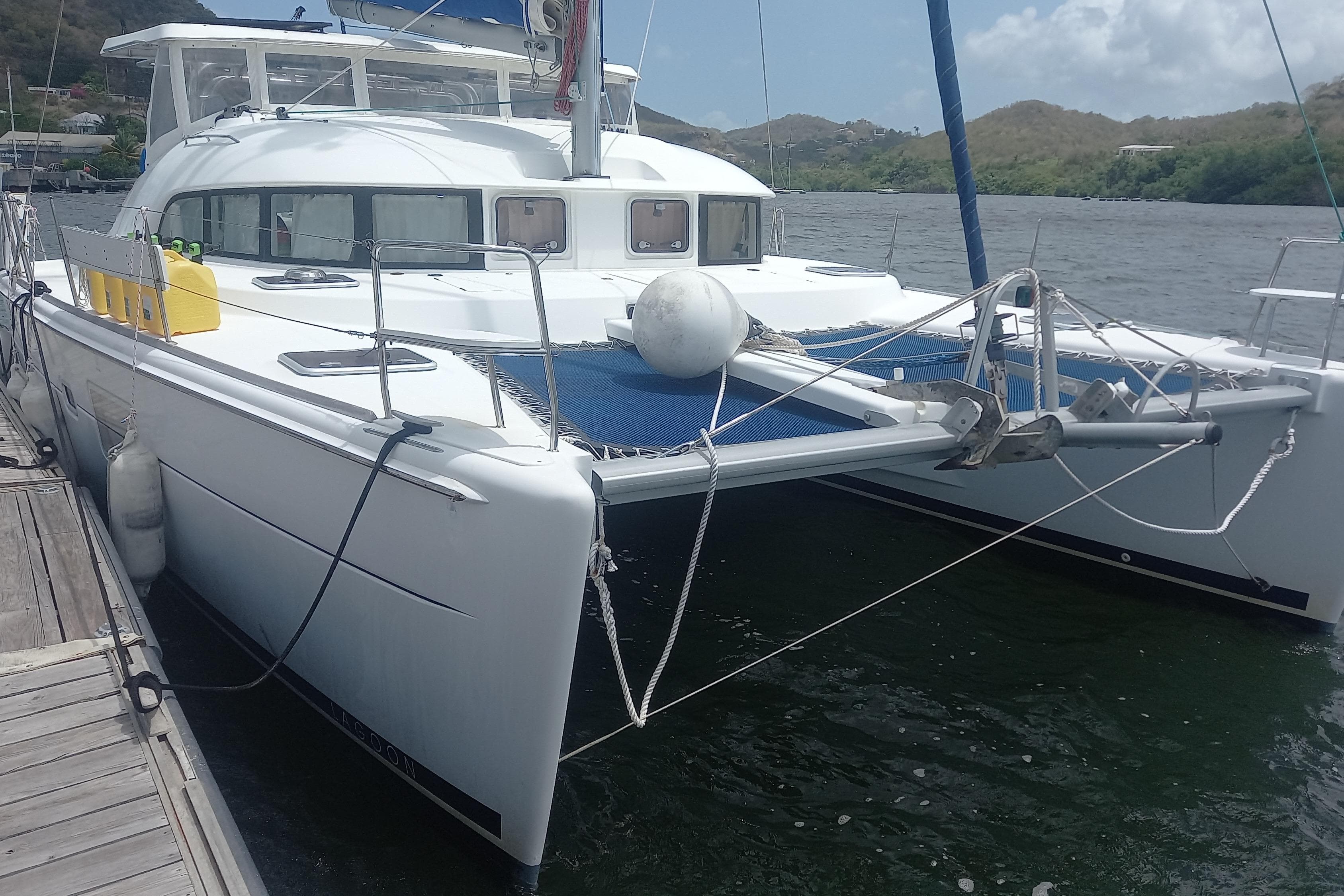 2008 Lagoon 380 S2 catamaran docked by the water, showcasing sleek design and spacious deck.