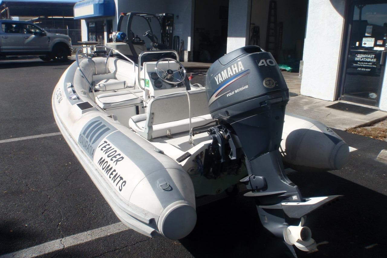 2003 Novurania DL 400 inflatable boat with Yamaha 40 outboard motor, parked outdoors.