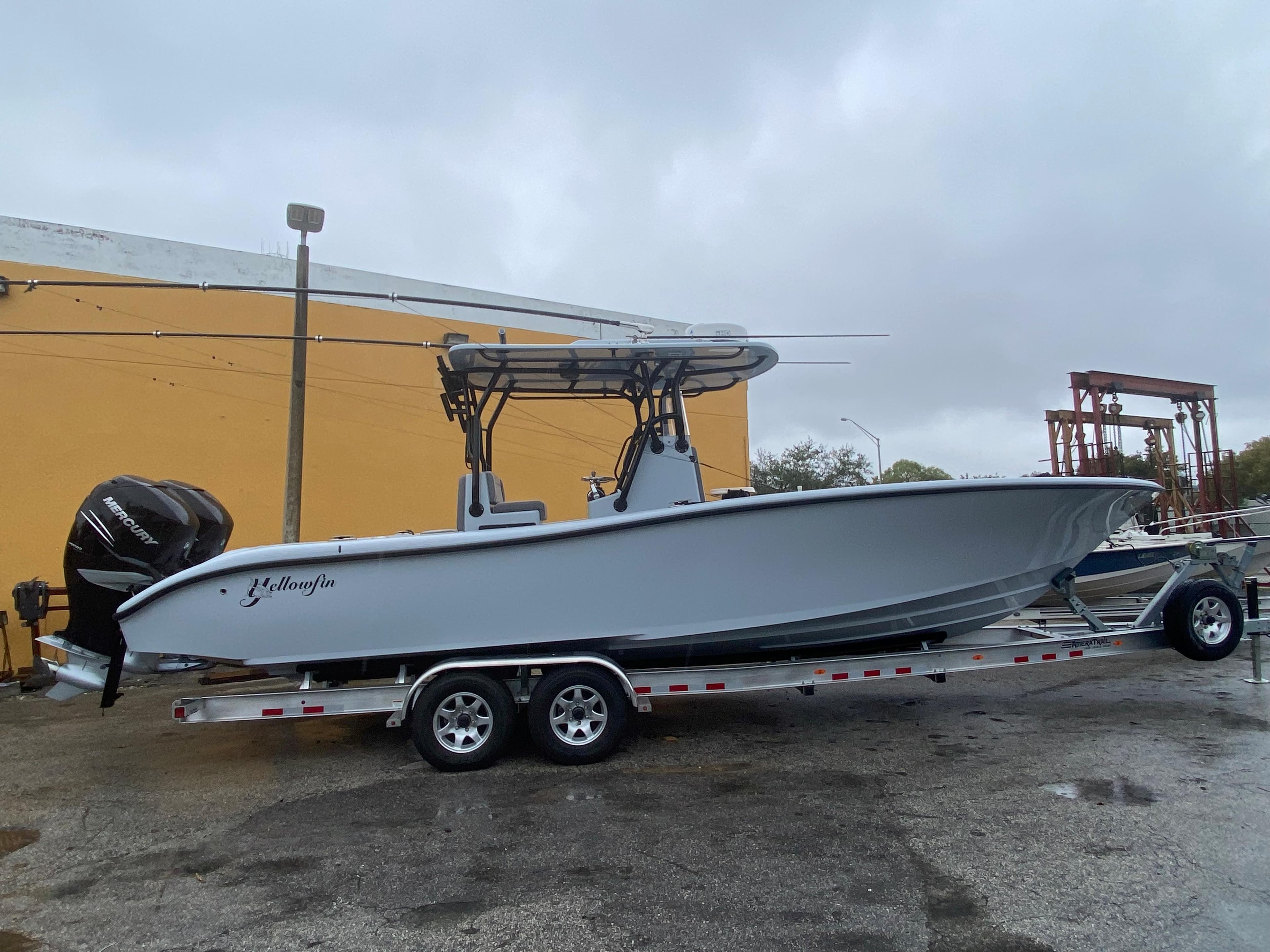 2021 Yellowfin 29 Offshore boat on trailer in front of yellow wall.