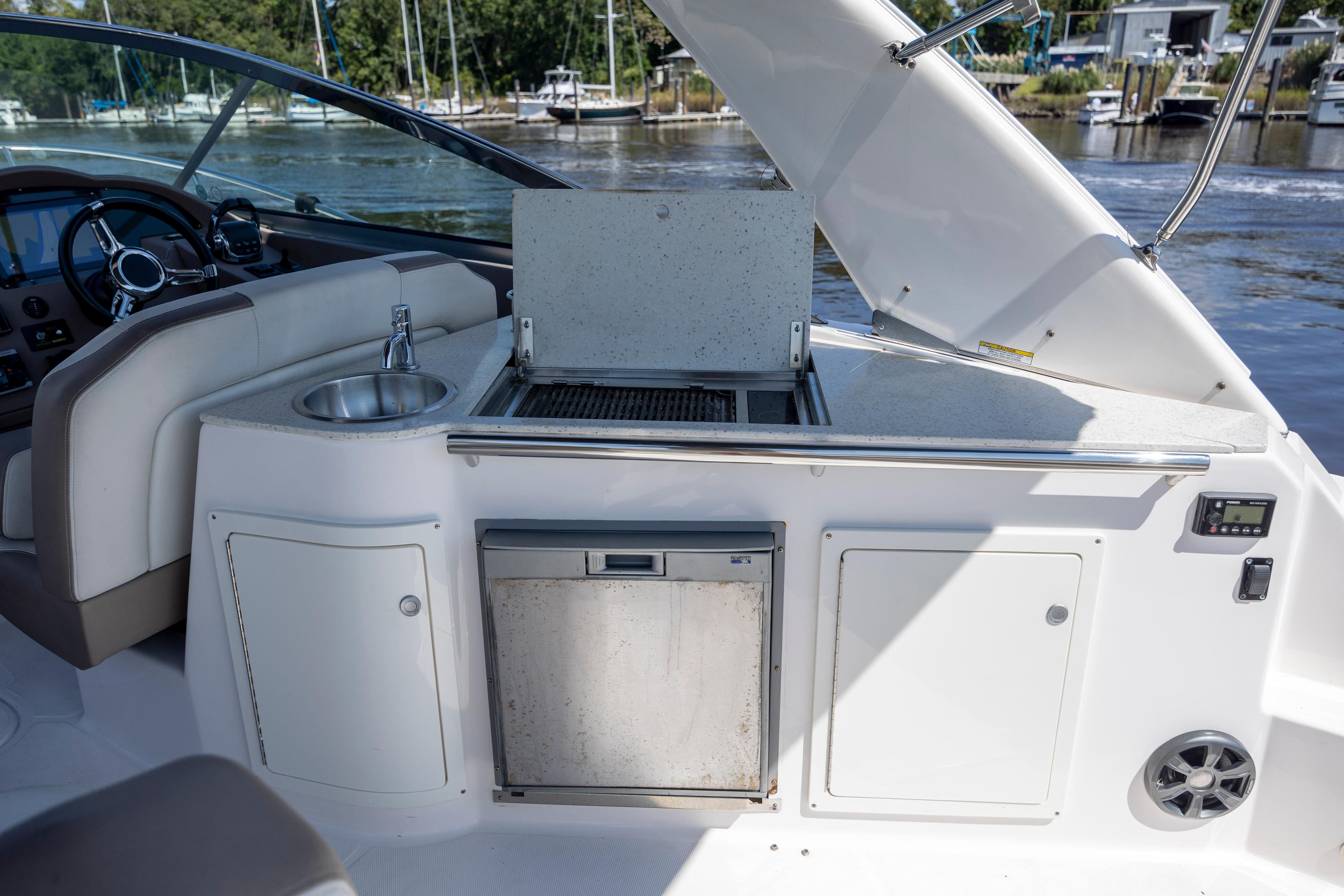 2017 Regal 32 Express yacht interior with kitchenette and sink, docked by the water.