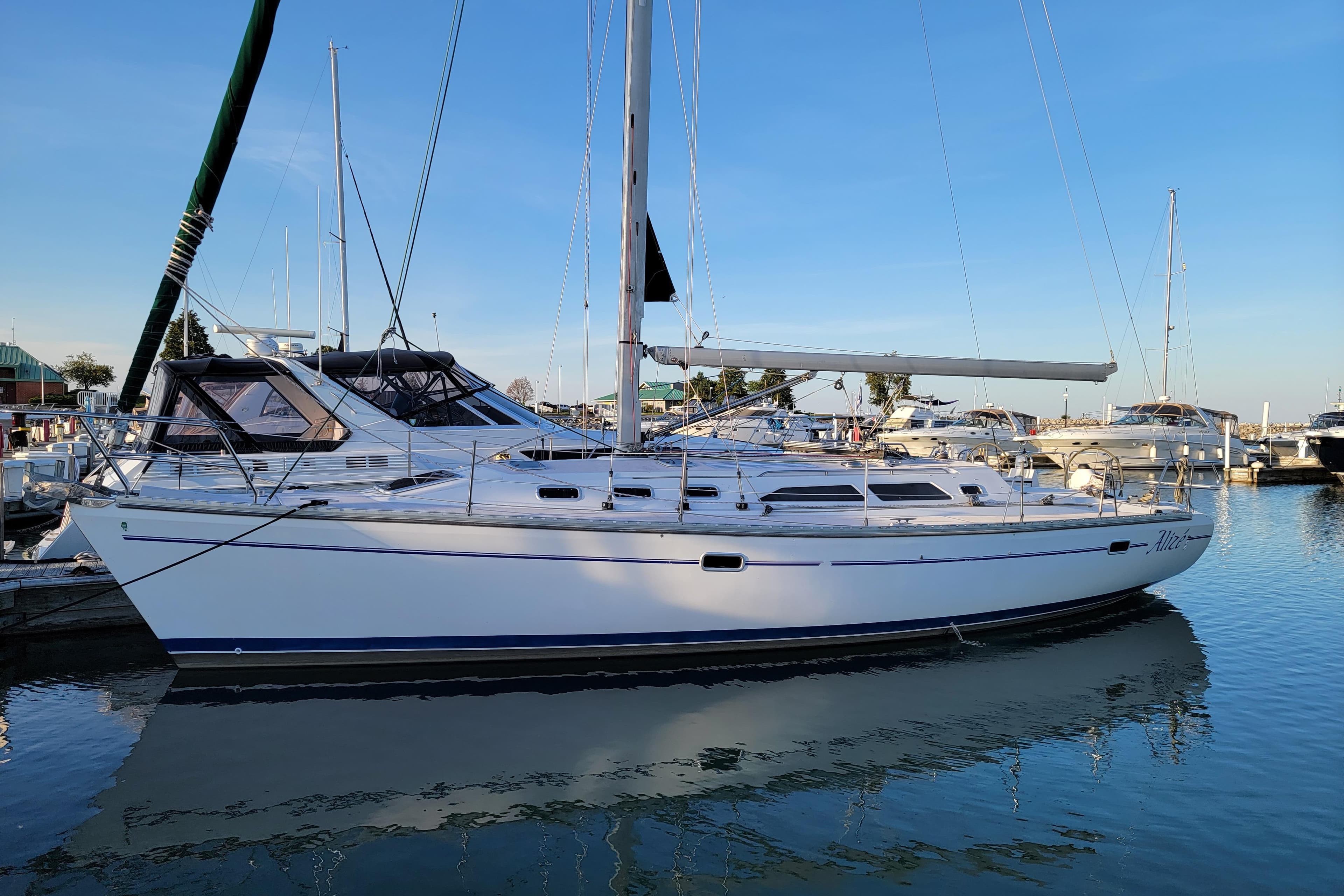 1999 Catalina 400 sailboat docked in a marina under clear blue skies.