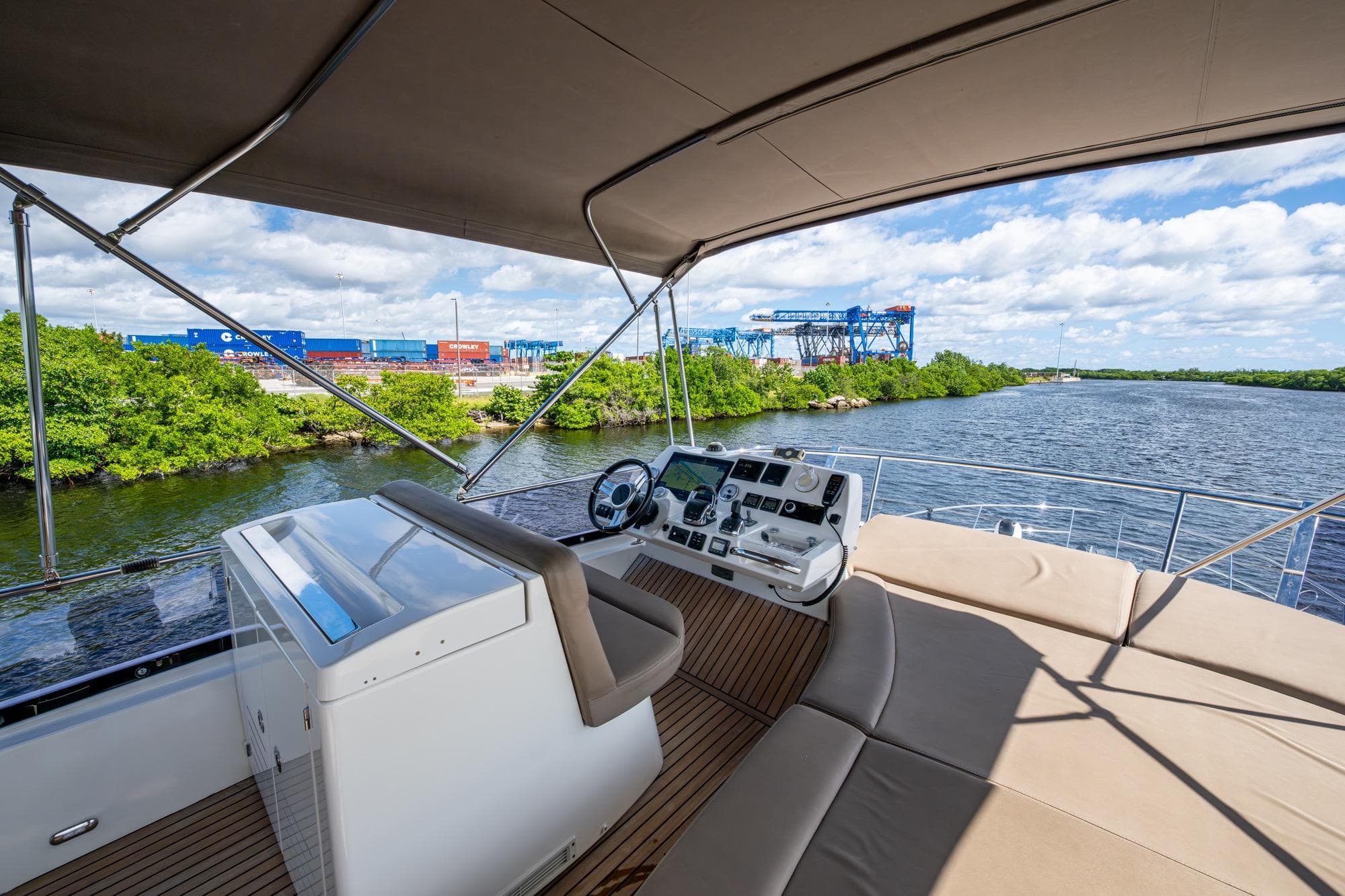 2012 Prestige Flybridge yacht helm with river view, featuring modern controls and comfortable seating.
