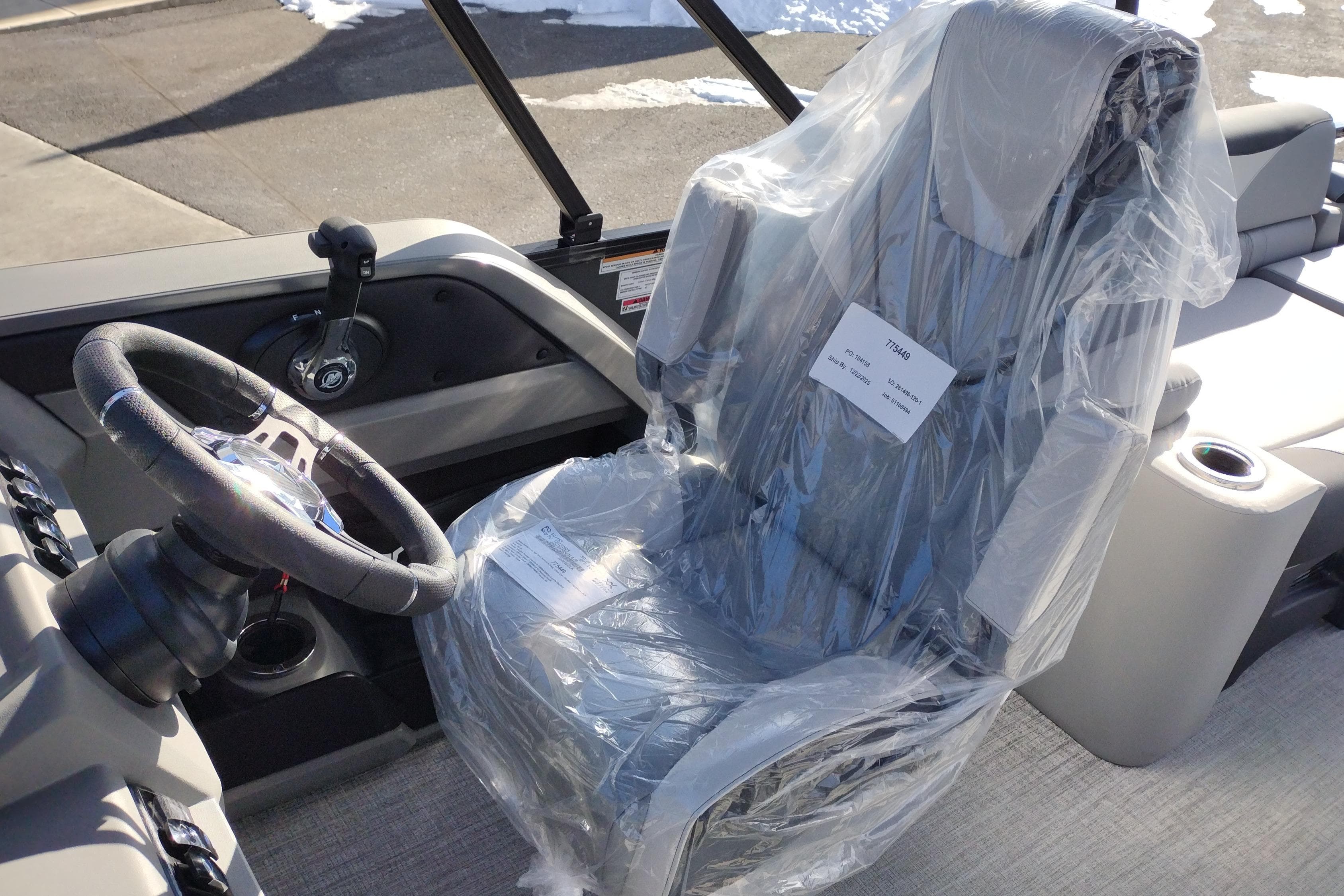 2026 Tahoe Pontoon 23 LTZ Quad Lounge captain's chair and steering wheel, wrapped in protective plastic.