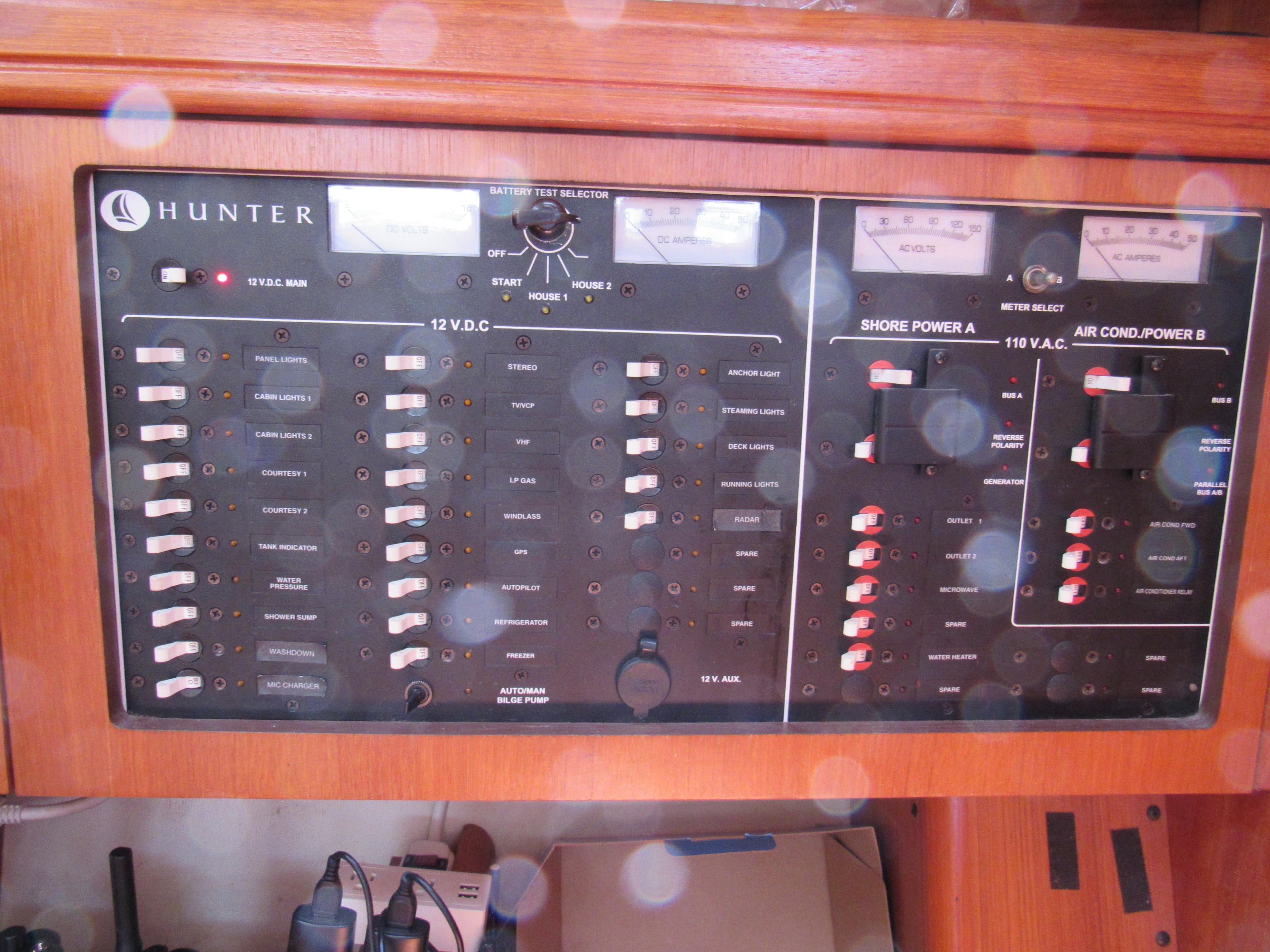 Electrical control panel on a 2002 Hunter 466 yacht, featuring various switches and meters.