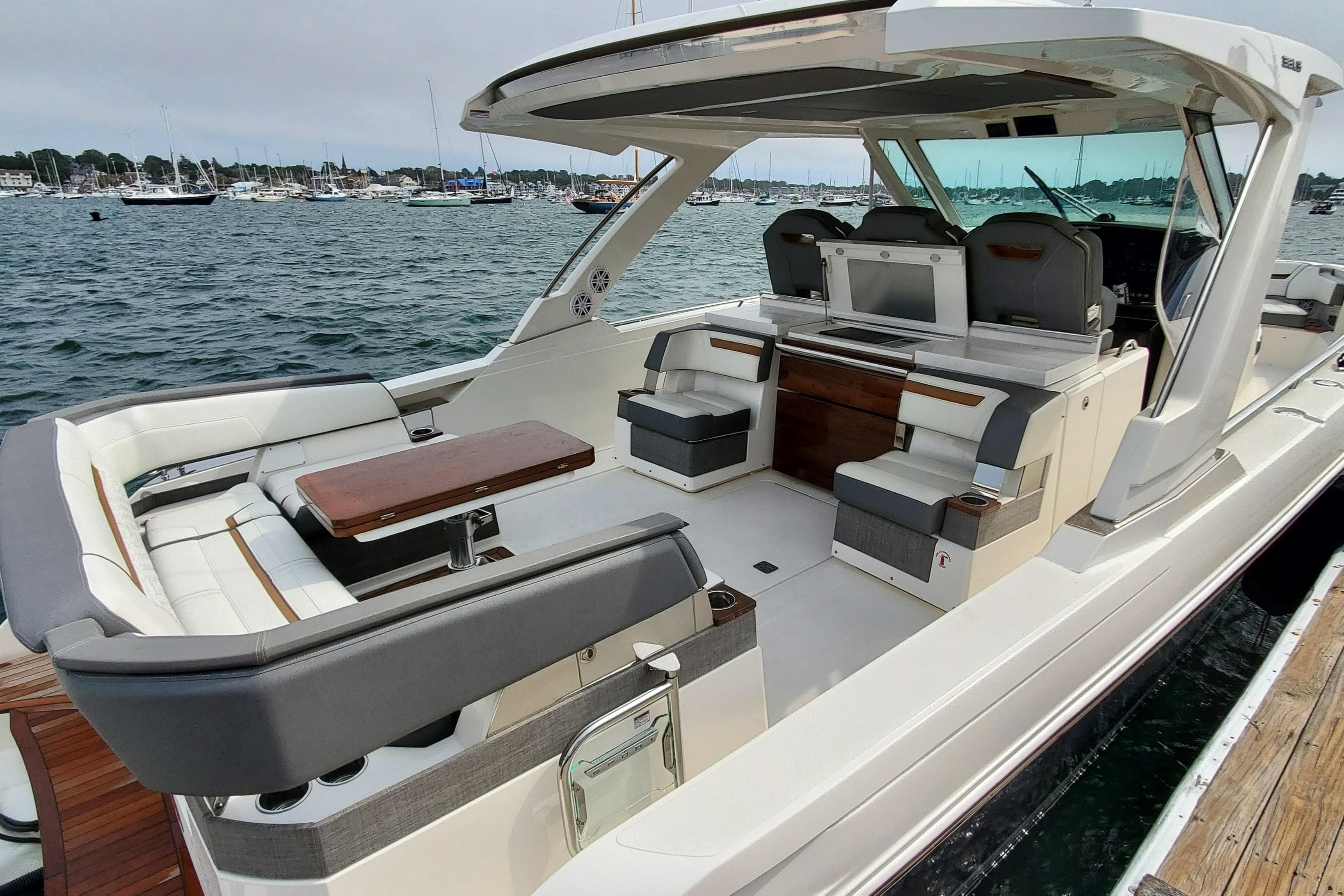 2021 Tiara Sport 38 LS luxury boat interior with seating and table, docked by the water.