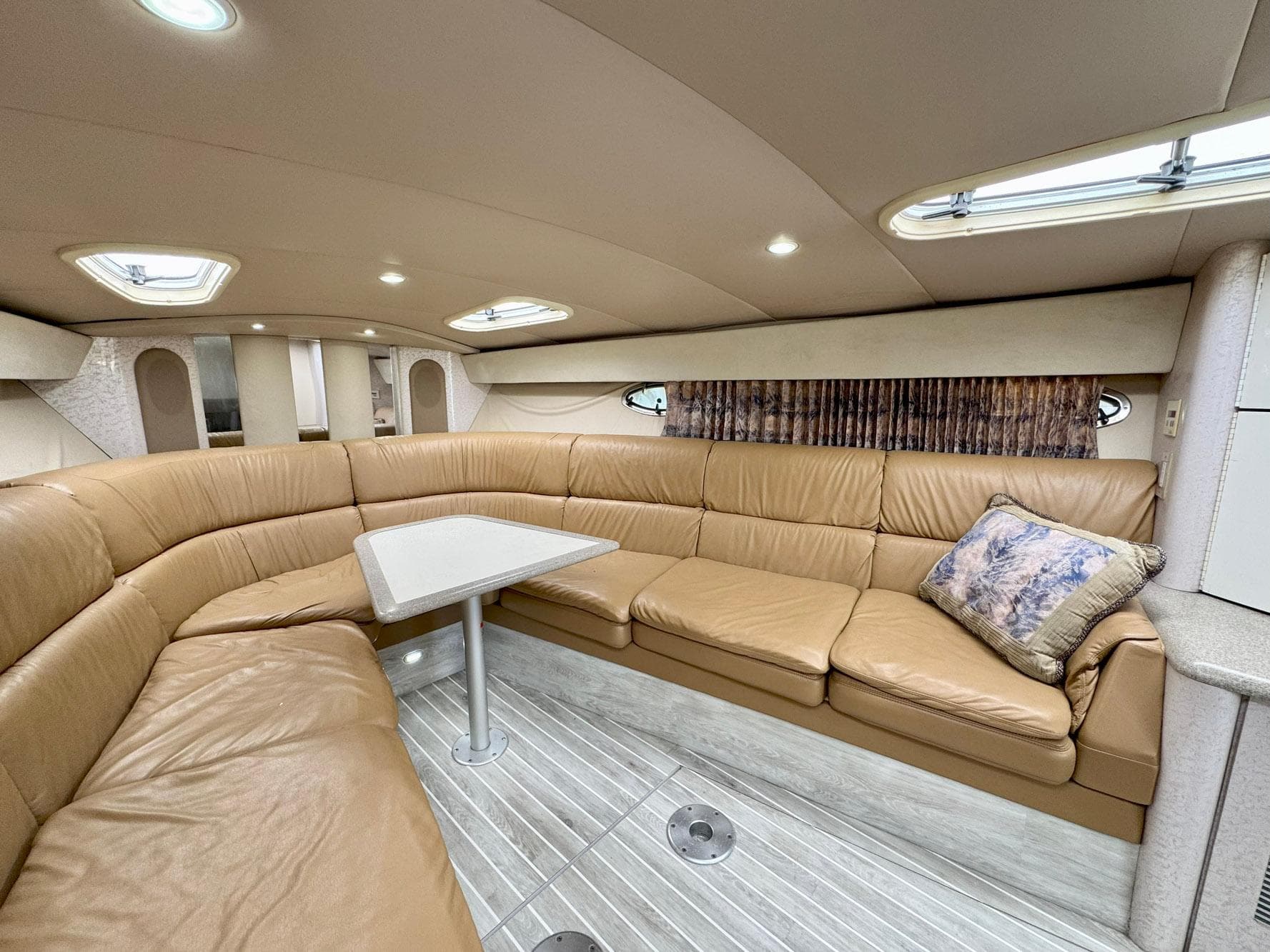 Luxurious interior of a 1999 Formula 400 Super Sport yacht with leather seating and table.