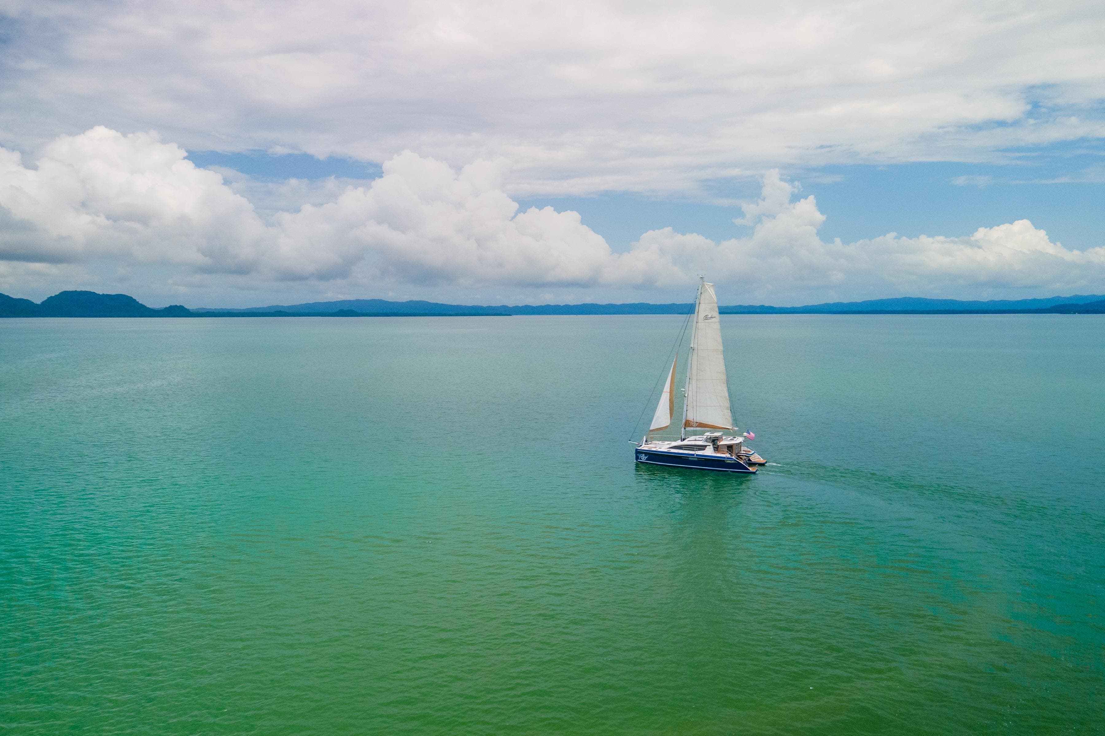 Sailboat Privilege 510 cruising on calm turquoise waters under a cloudy sky, 2023.