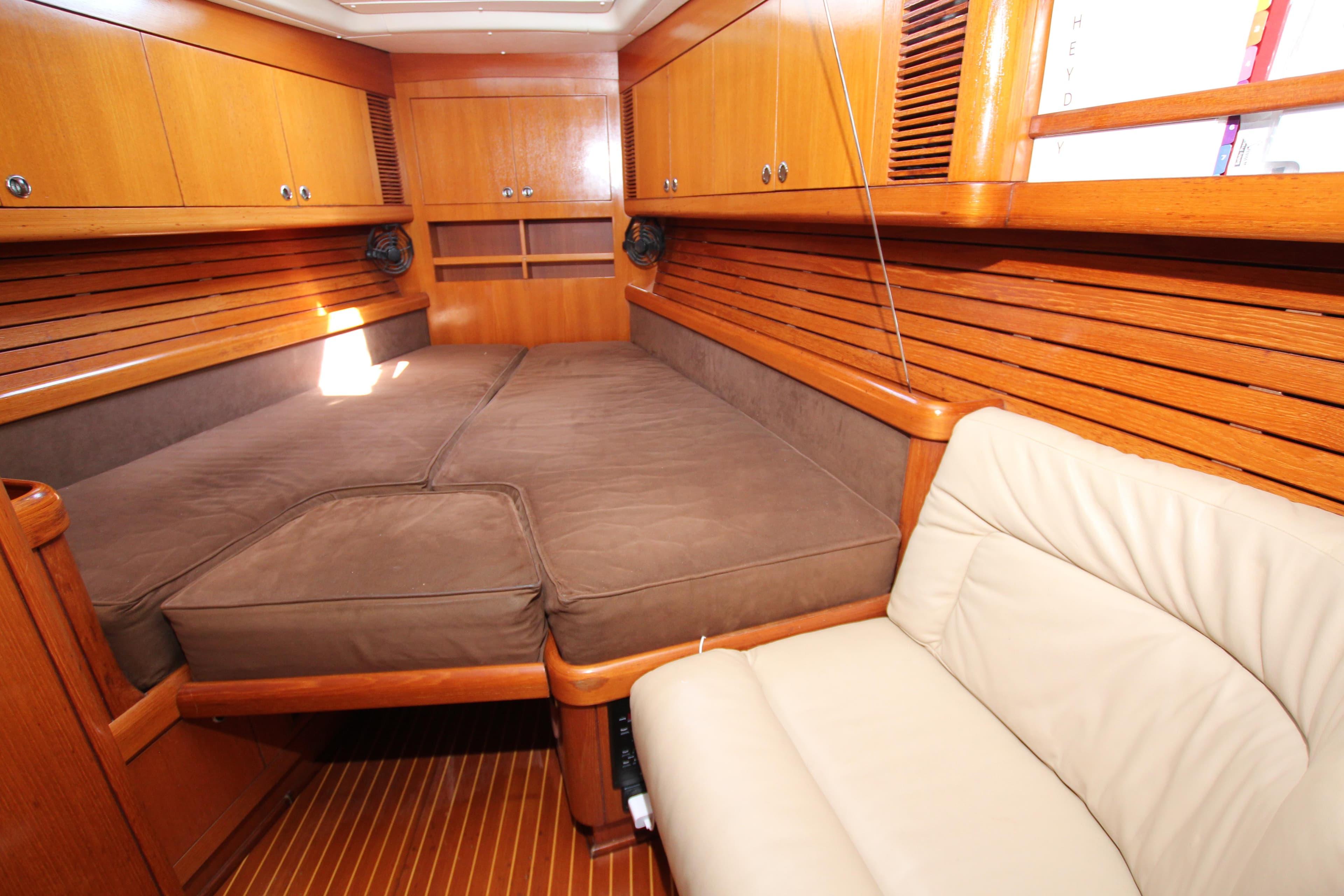 Luxurious cabin interior of 1997 Nautor Swan 48 yacht with wooden finish and comfortable seating.
