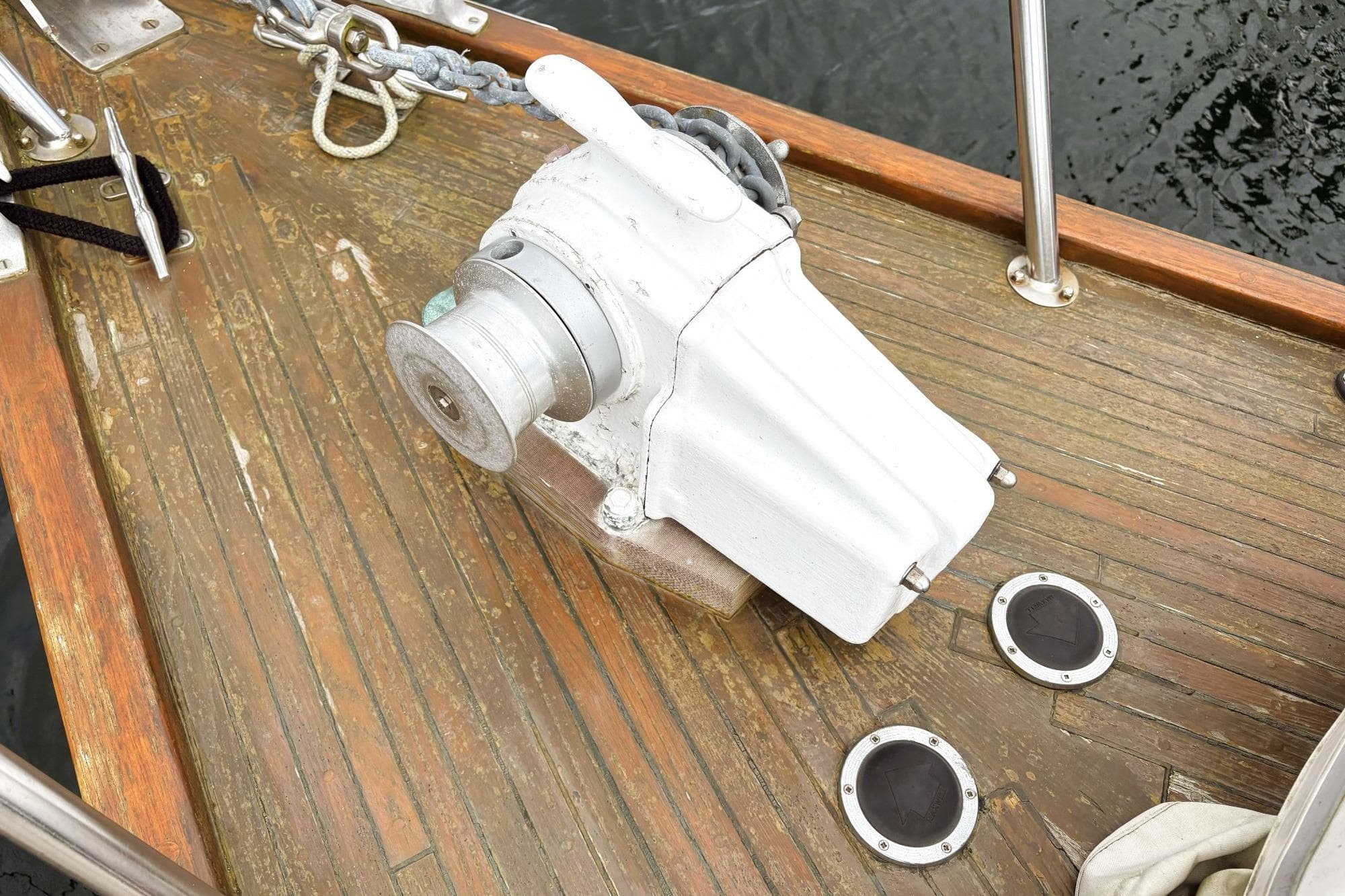 Anchor winch on wooden deck of 1980 Discovery 42 sailboat.