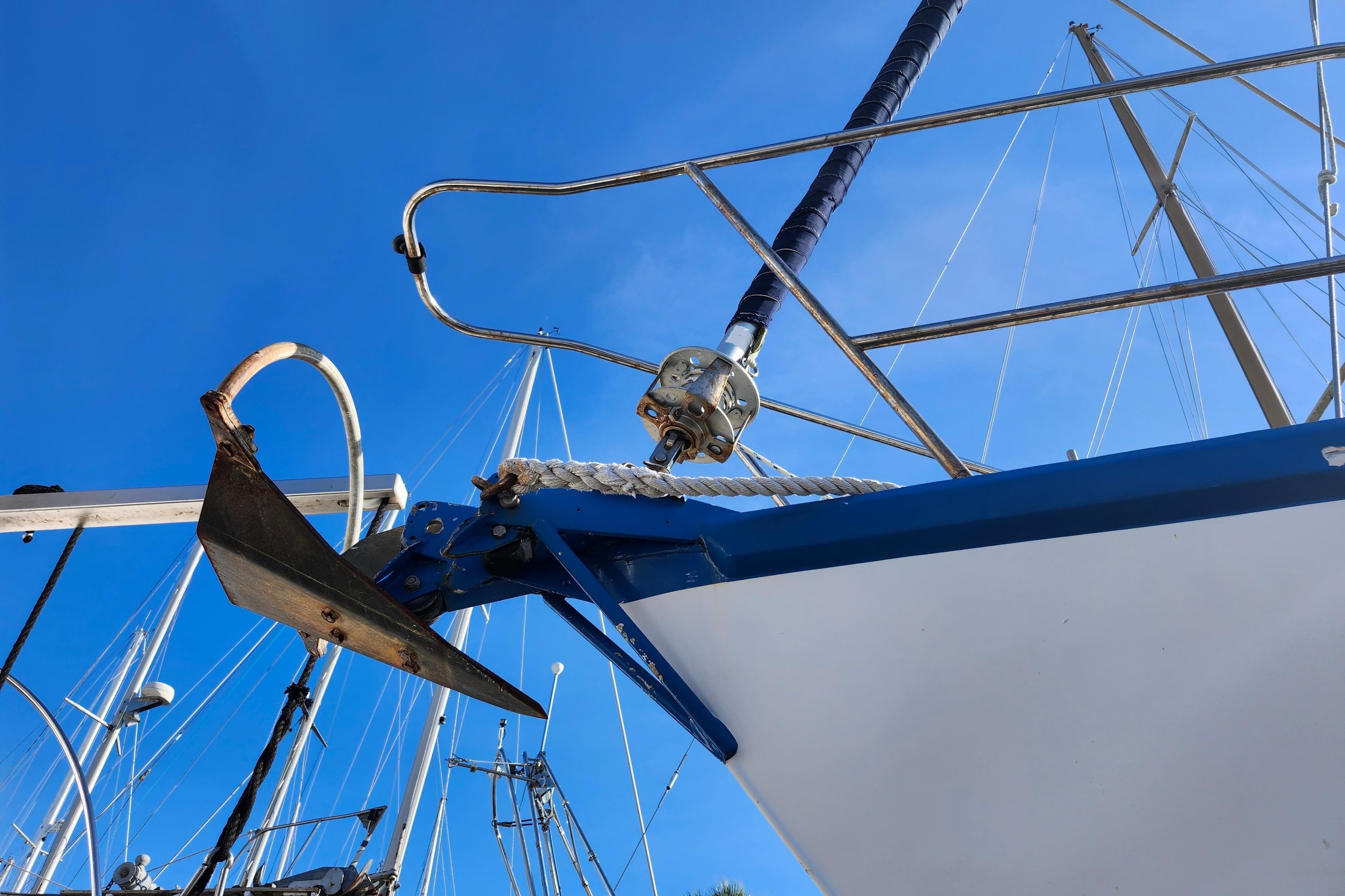 Custom Weld Exploration 1987 boat anchor and bow against clear blue sky.