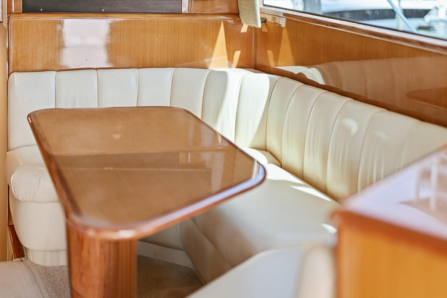 Luxurious interior of 2002 Viking 61 Convertible yacht with elegant seating and wooden table.