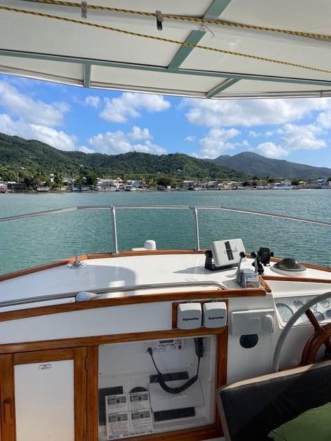 1986 Grand Banks 42 Classic yacht with scenic coastal view and mountains in the background.
