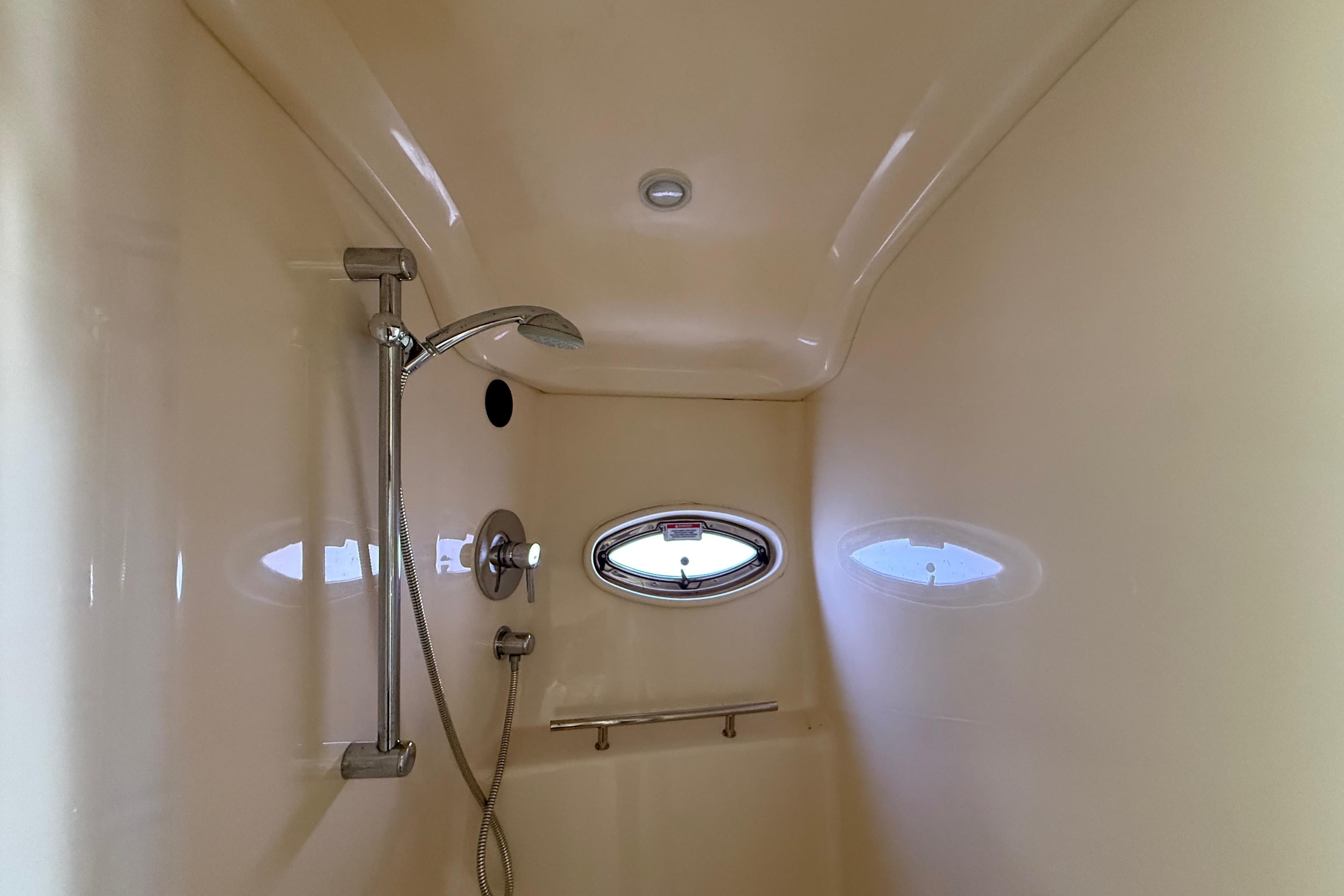 Shower area inside 2008 Sea Ray 38 Sundancer yacht, featuring sleek design and porthole window.
