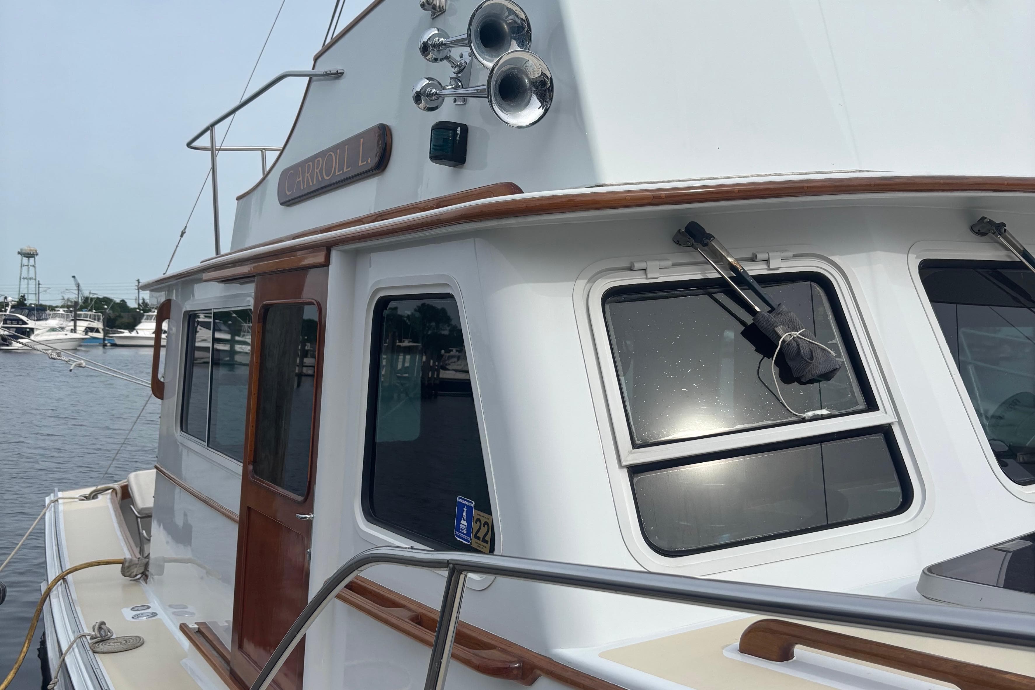 Boat docked at marina, Lowell 40 model, 2001, with wooden accents and windows.