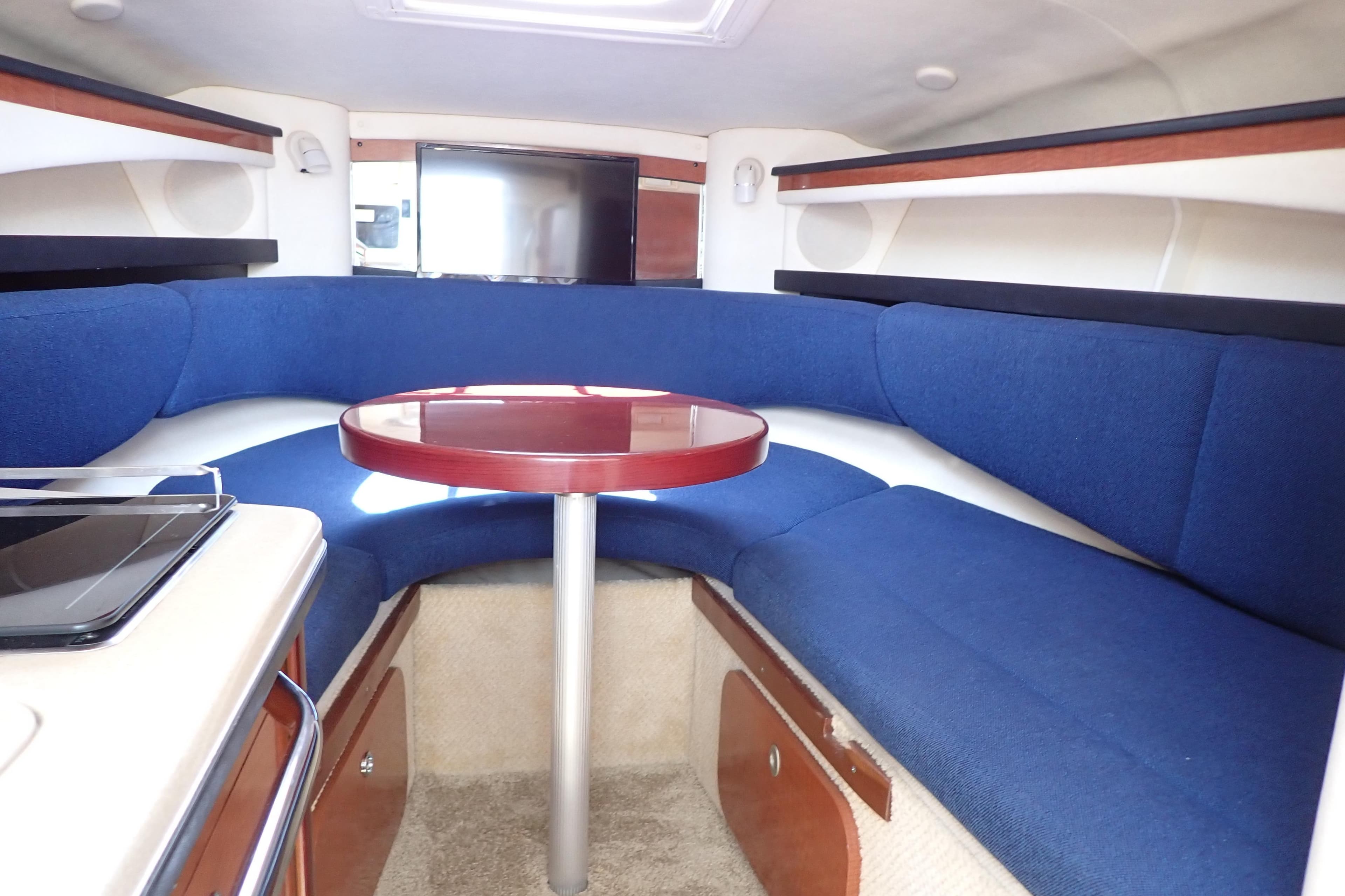 Interior of 2005 Sea Ray Sundancer 260 with blue seating and round table.