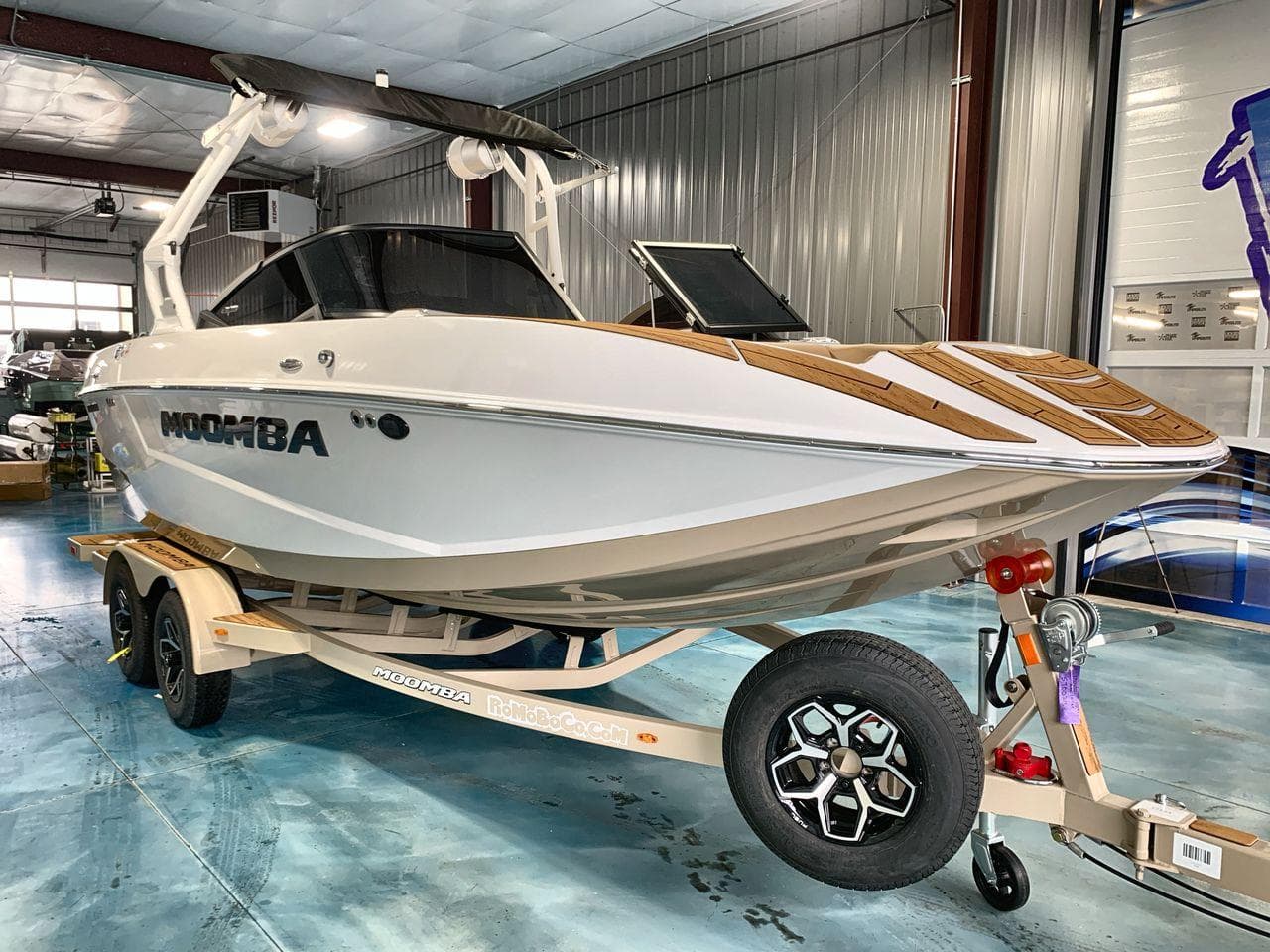 2025 Moomba Mondo boat on trailer in indoor showroom setting.
