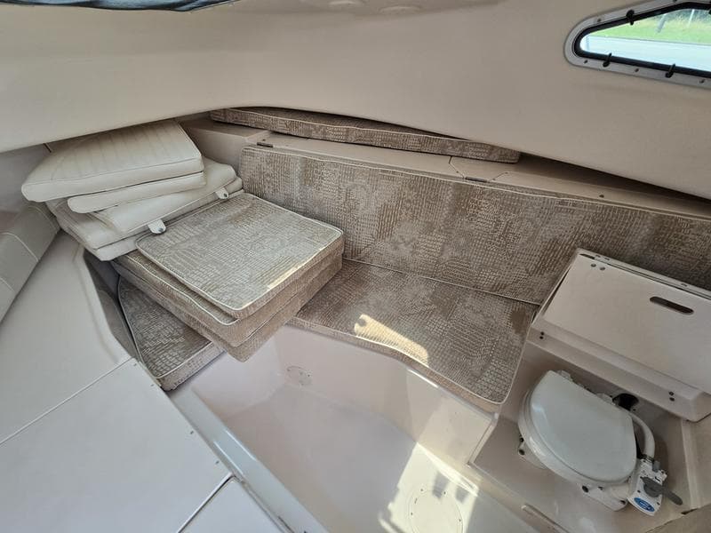 2007 Grady-White 232 Gulfstream cabin interior with seating and compact toilet.