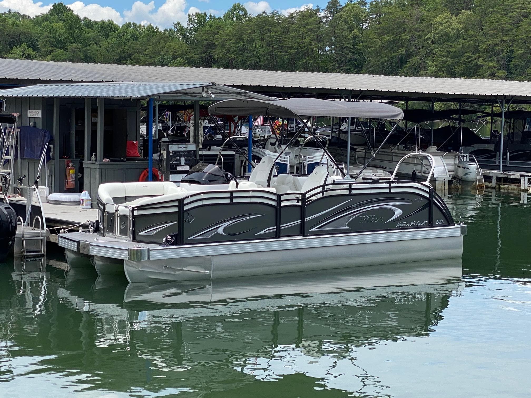 2024 JC Neptoon Sport 23TT DSL pontoon boat docked at marina.