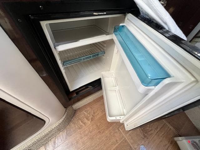 Open refrigerator inside 2017 Sea Ray 330 Sundancer boat, showing interior shelves and door storage.