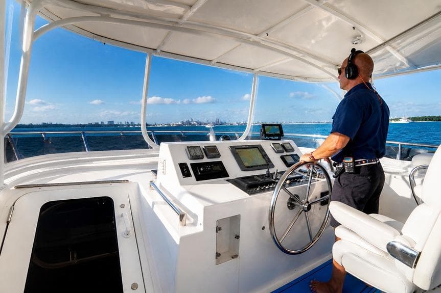 Person steering 2005 Symbol 58 Pilothouse yacht on open water.