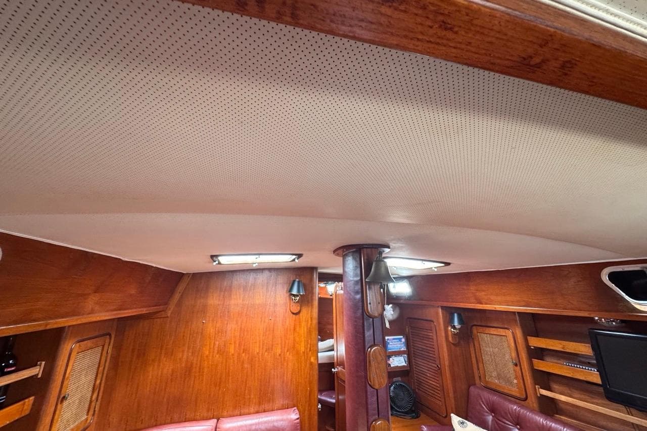Interior of 1981 Gulfstar 44 Mk II Sloop, featuring wood paneling and cozy seating area.