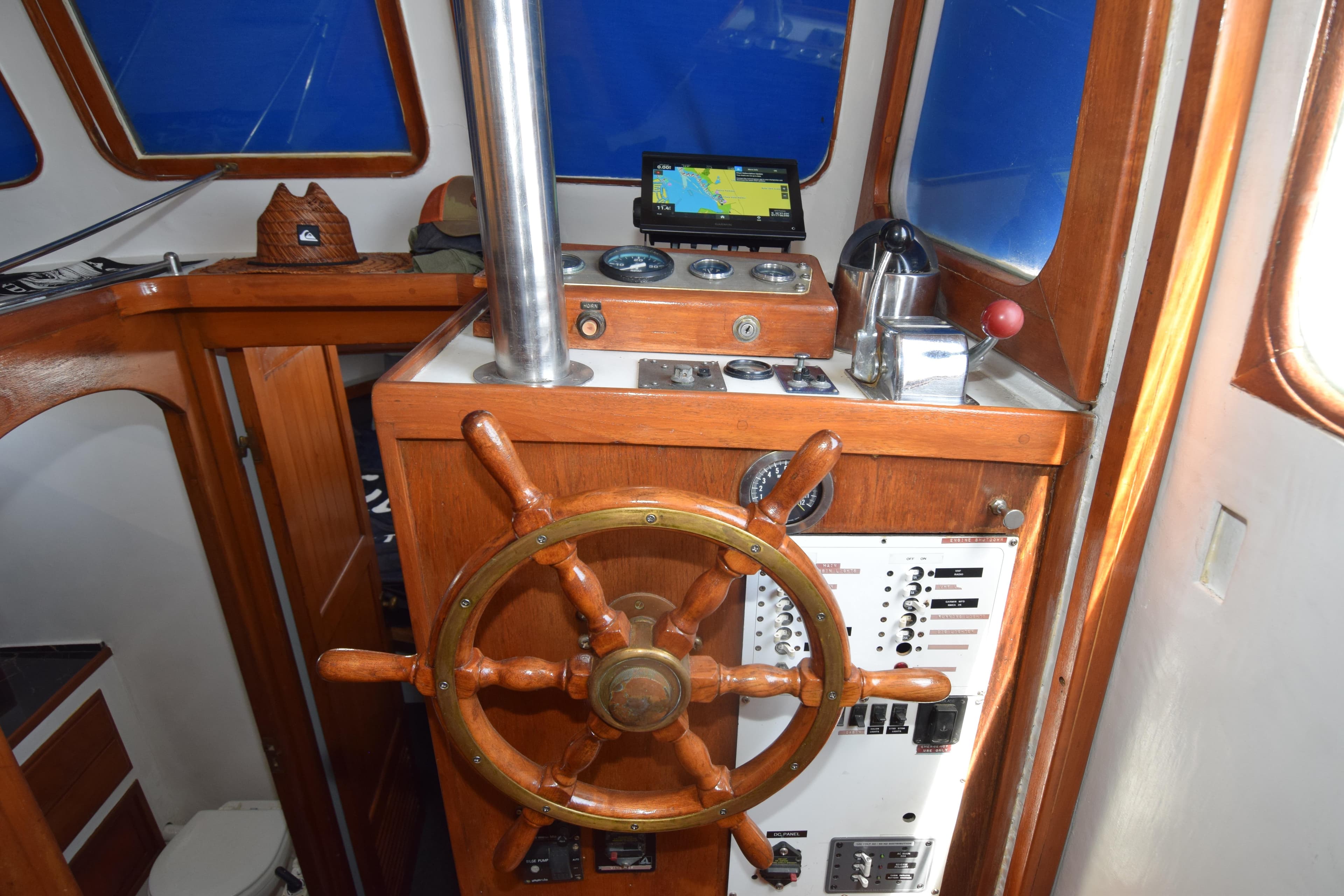 1972 CHB 34 boat helm with wooden wheel, navigation instruments, and control panel.