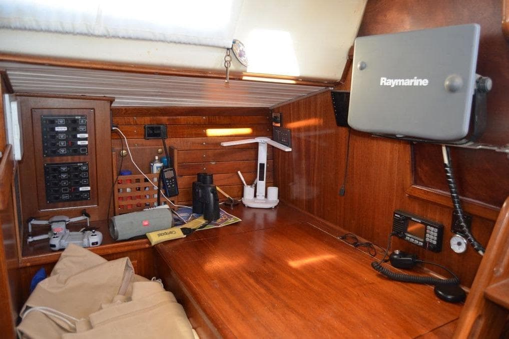 Navigation station inside a 1974 Bowman 46 sailboat with Raymarine equipment and wooden interior.