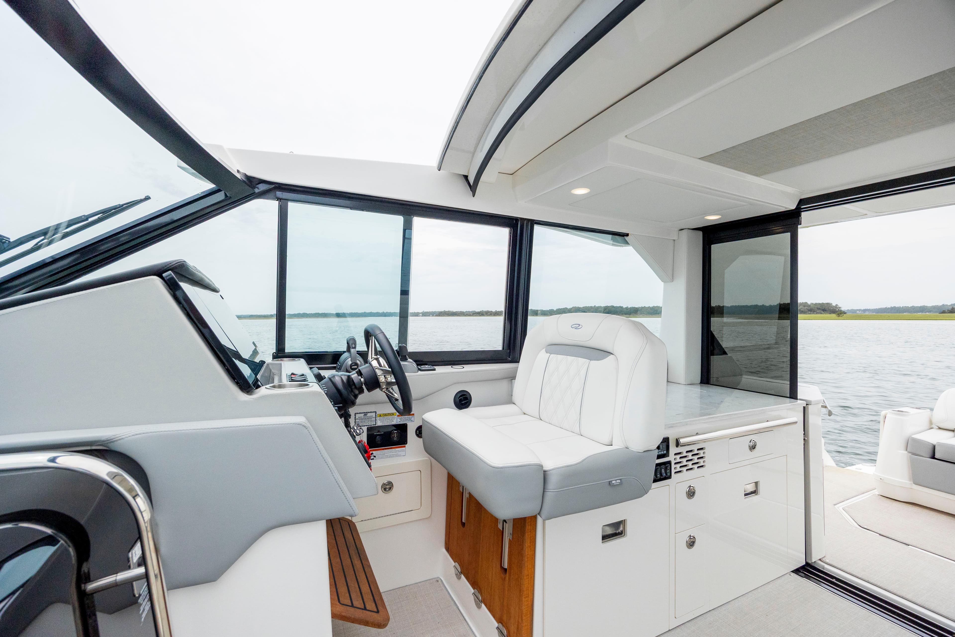 Interior of 2022 Regal 36 Grande Coupe yacht with helm and seating area.