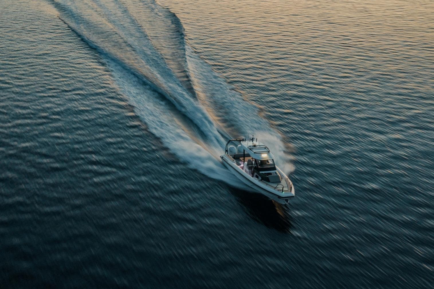 Highfield ADV7 2026 boat cruising on calm water at sunset.