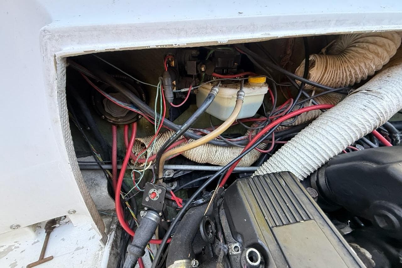 Engine compartment of a 1965 Bertram boat with visible wiring and components.