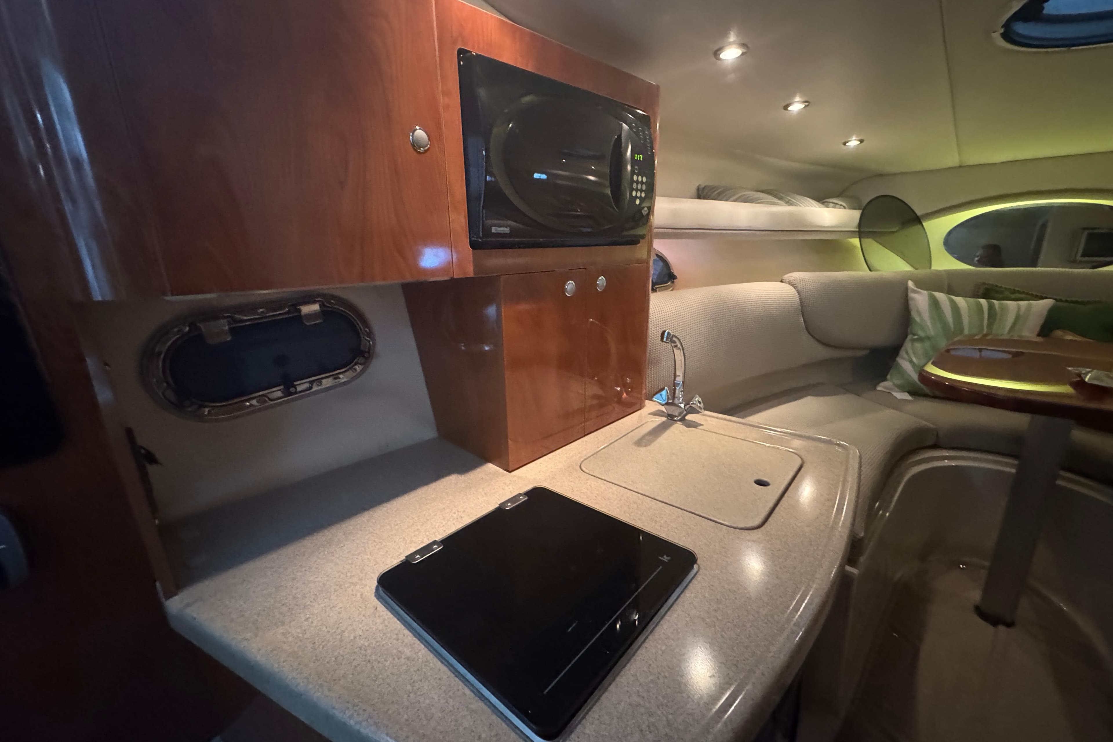 2004 Four Winns 268 Vista cabin interior with kitchenette and seating area.