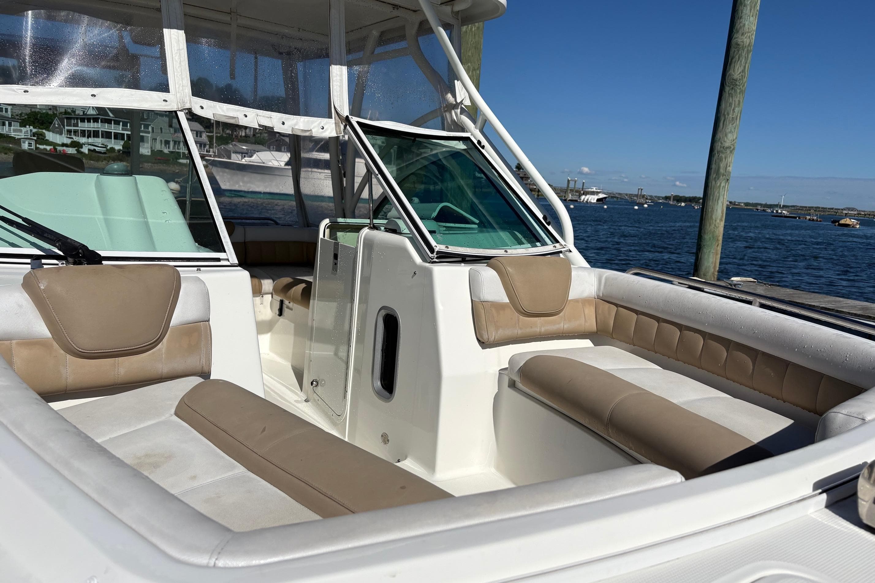 2016 Glacier Bay 2740 Dual Console boat interior with beige seating, docked by the water.