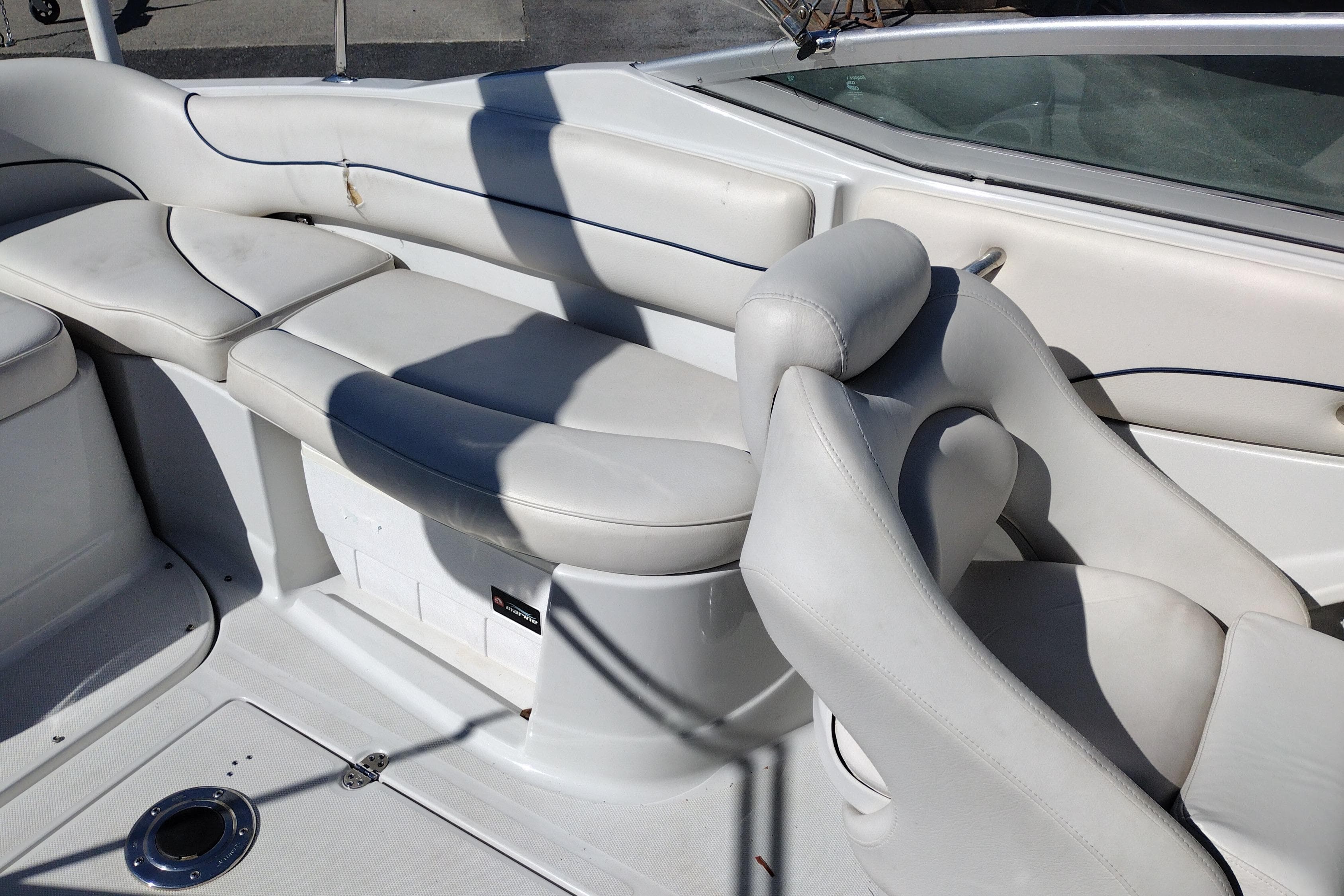 Interior seating of a 2005 Crownline 240 EX boat, featuring white cushioned seats.