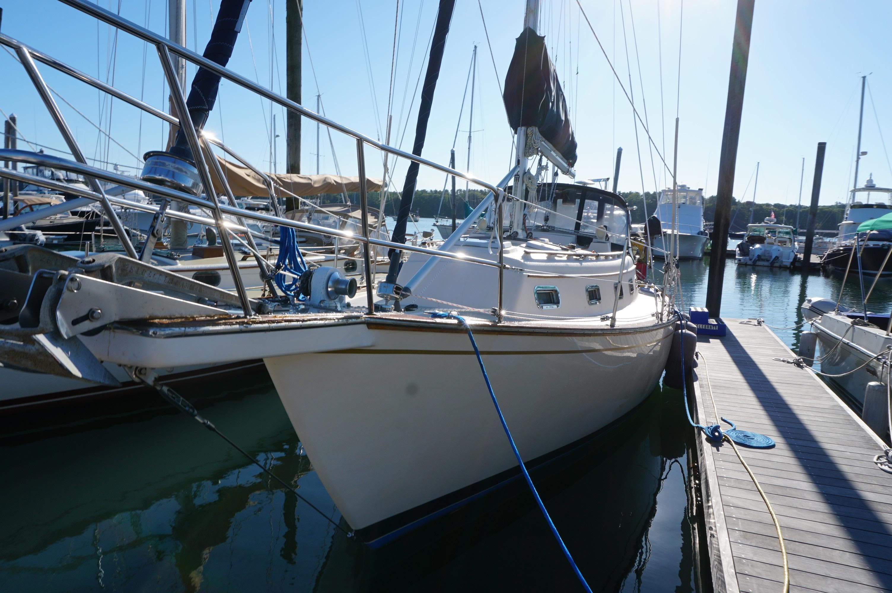 1994 Island Packet 32 sailboat docked at marina under clear blue sky.