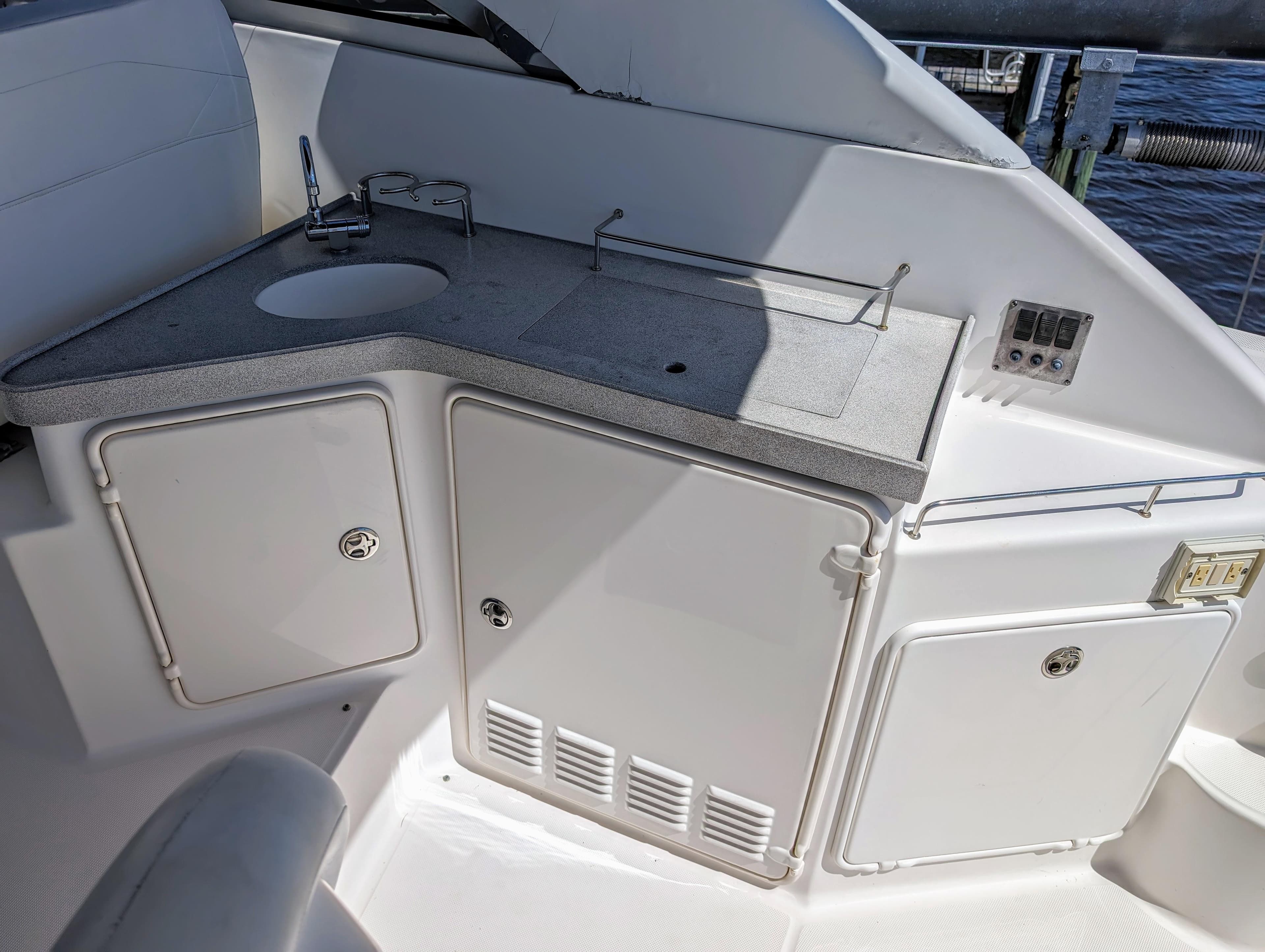 2005 Regal 3560 yacht kitchenette with sink, storage cabinets, and control panel.